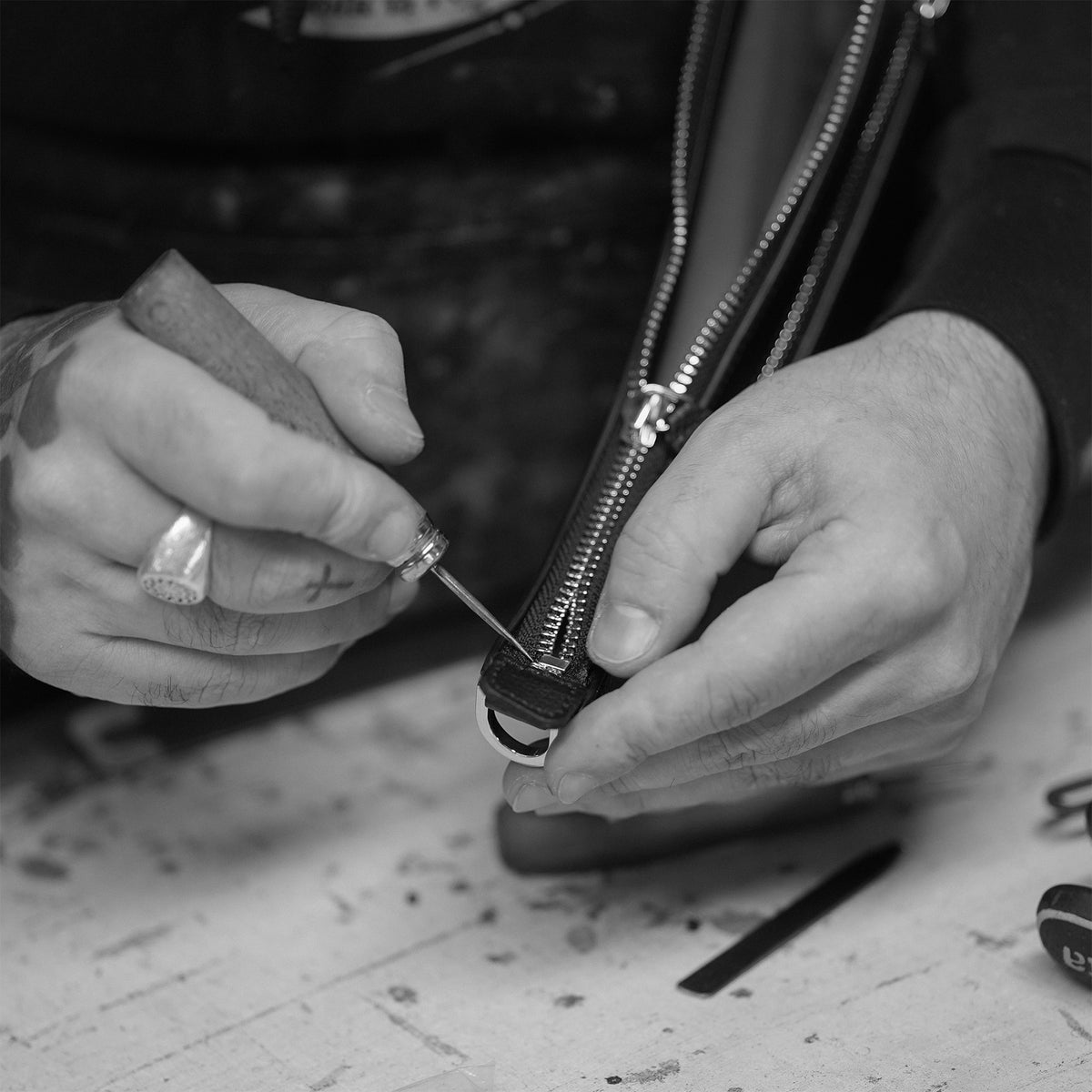 ALEMI Zurich | HELVETIA | Craftsmanship | Craftsman finishing the zip by hand