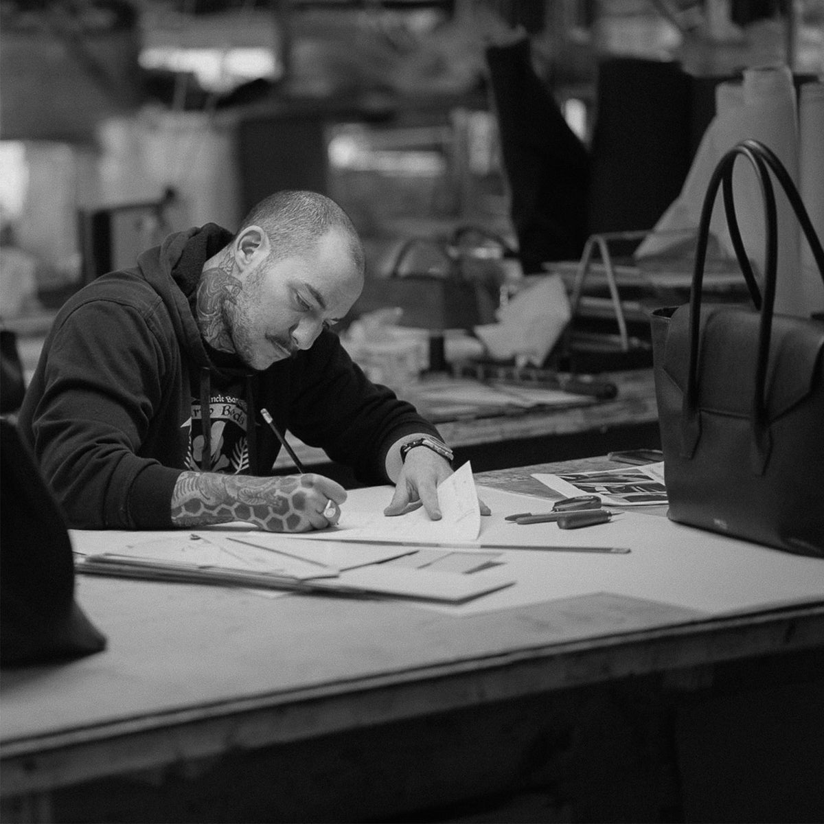 ALEMI Zurich | IDA | Craftsmanship | Craftsman marking a pattern at the workbench