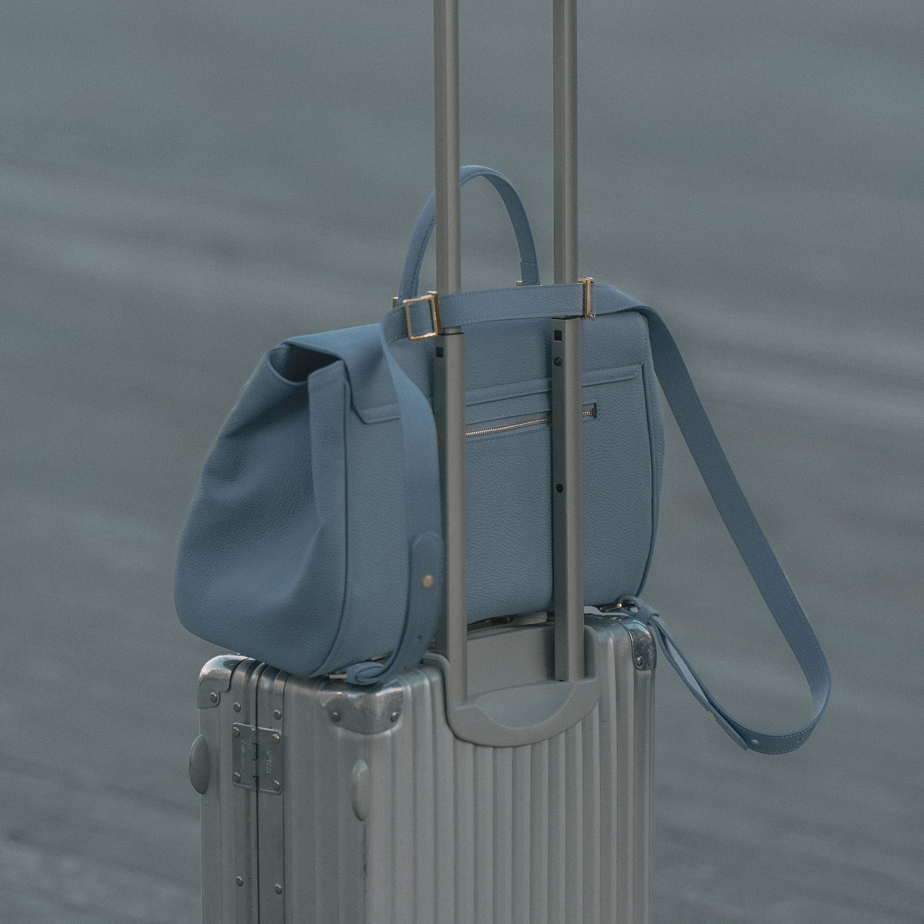 ALEMI Zurich | BELLEVUE | Laptop Bag | Ice Blue | Softgrain Leather | On suitcase