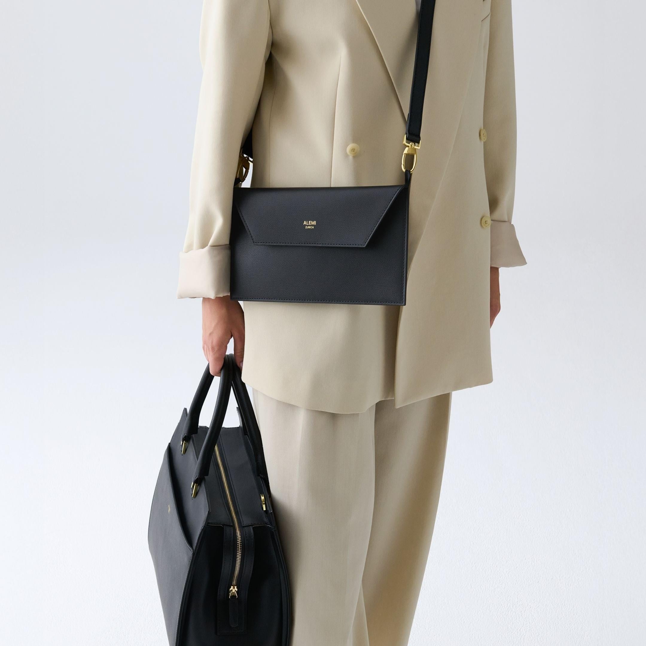 ALEMI Zurich | CENTRAL | Laptop Bag | Black | Pebbled Leather | Model carrying bag by handle close up