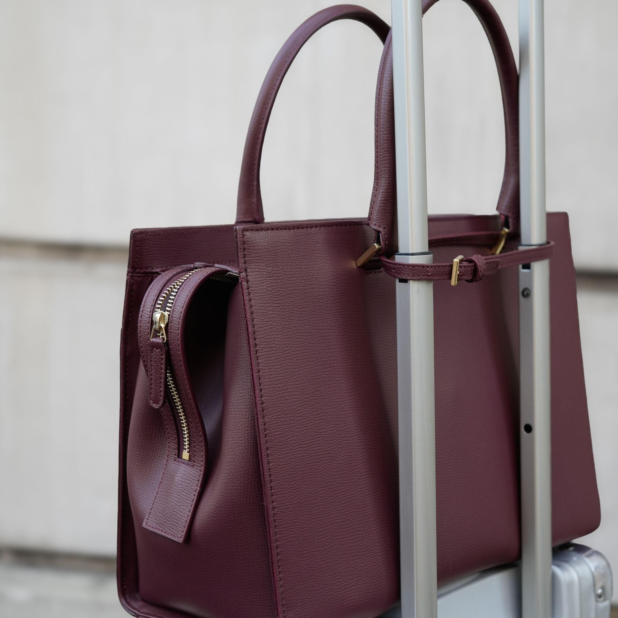 ALEMI Zurich | CENTRAL | Laptop Bag | Maroon Red | Pebbled Leather | Bag on suitcase