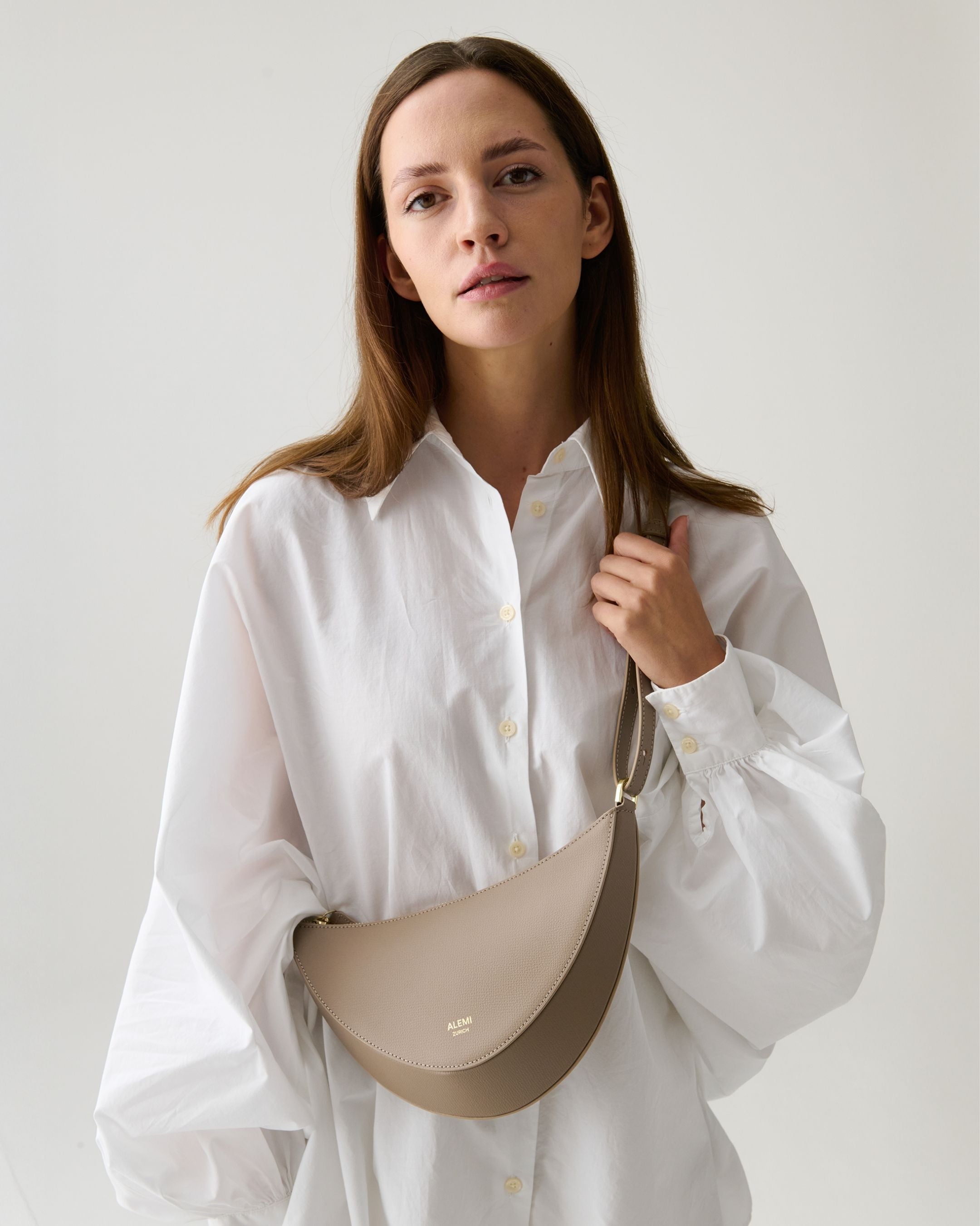ALEMI Zurich | HELVETIA | Small Bag | Greige | Pebbled Leather | Model carrying bag cross body close up