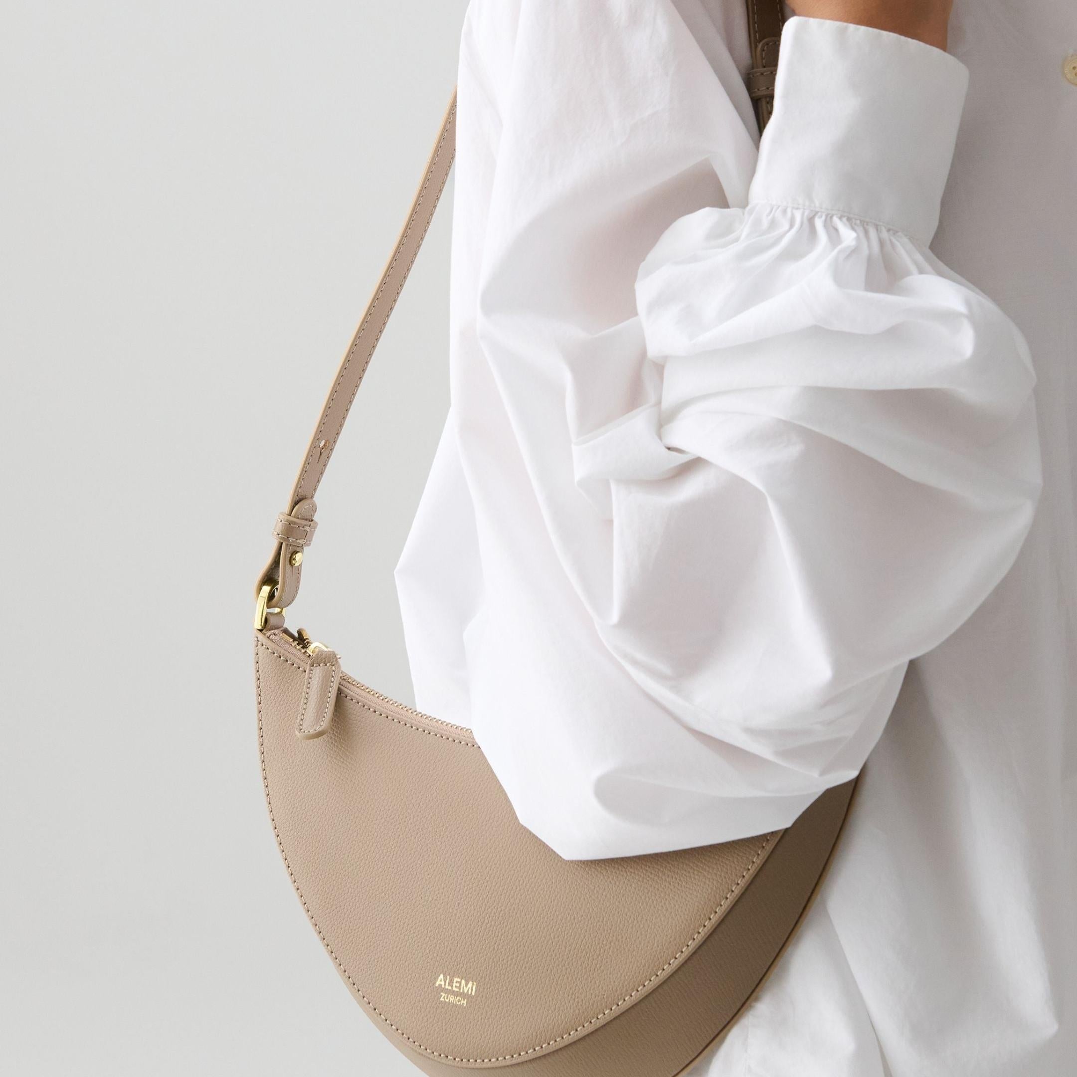 ALEMI Zurich | HELVETIA | Small Bag | Greige | Pebbled Leather | Model carrying bag on shoulder