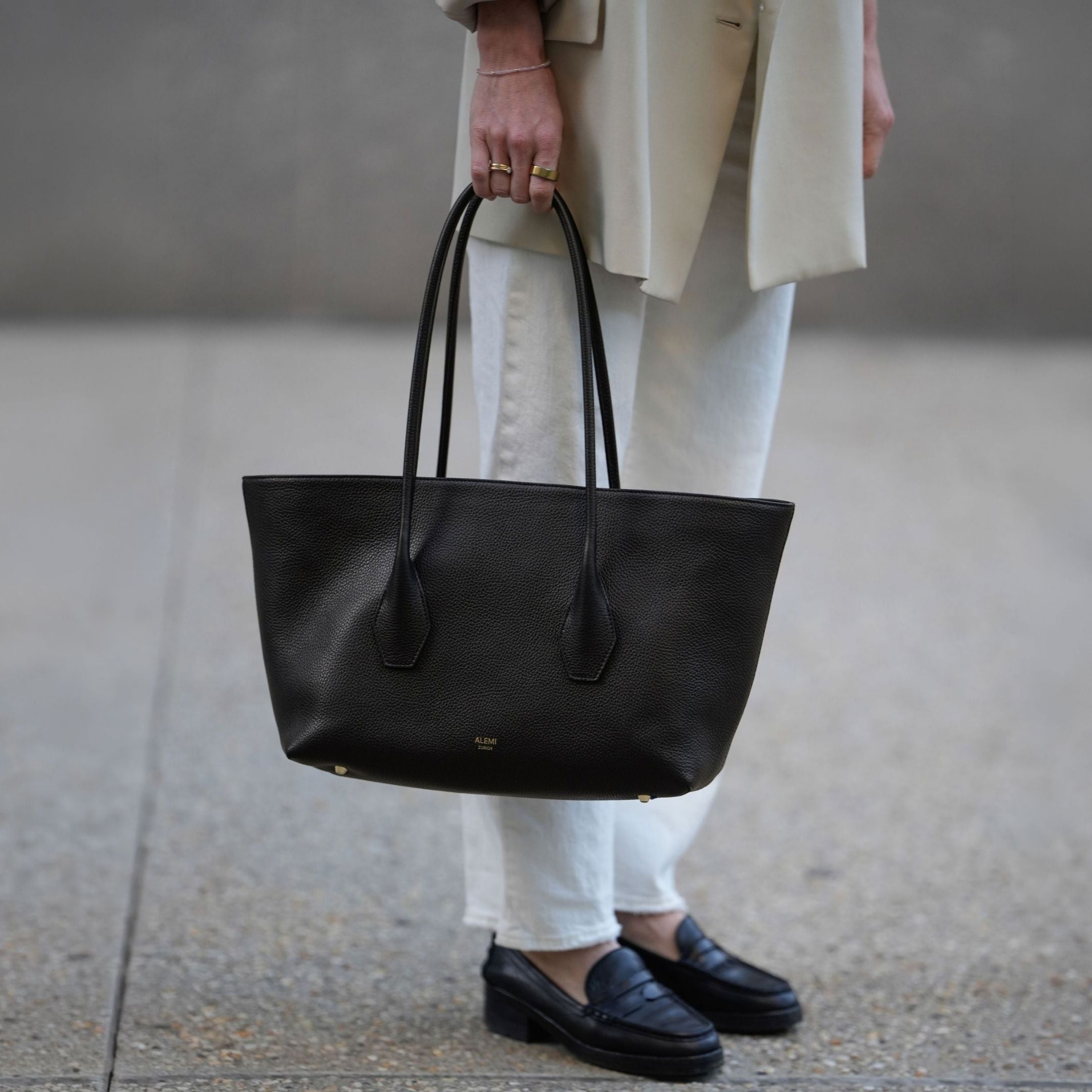 ALEMI Zurich | IDA | Laptop Bag | Black | Soft Grain Leather | Model carrying bag by handle