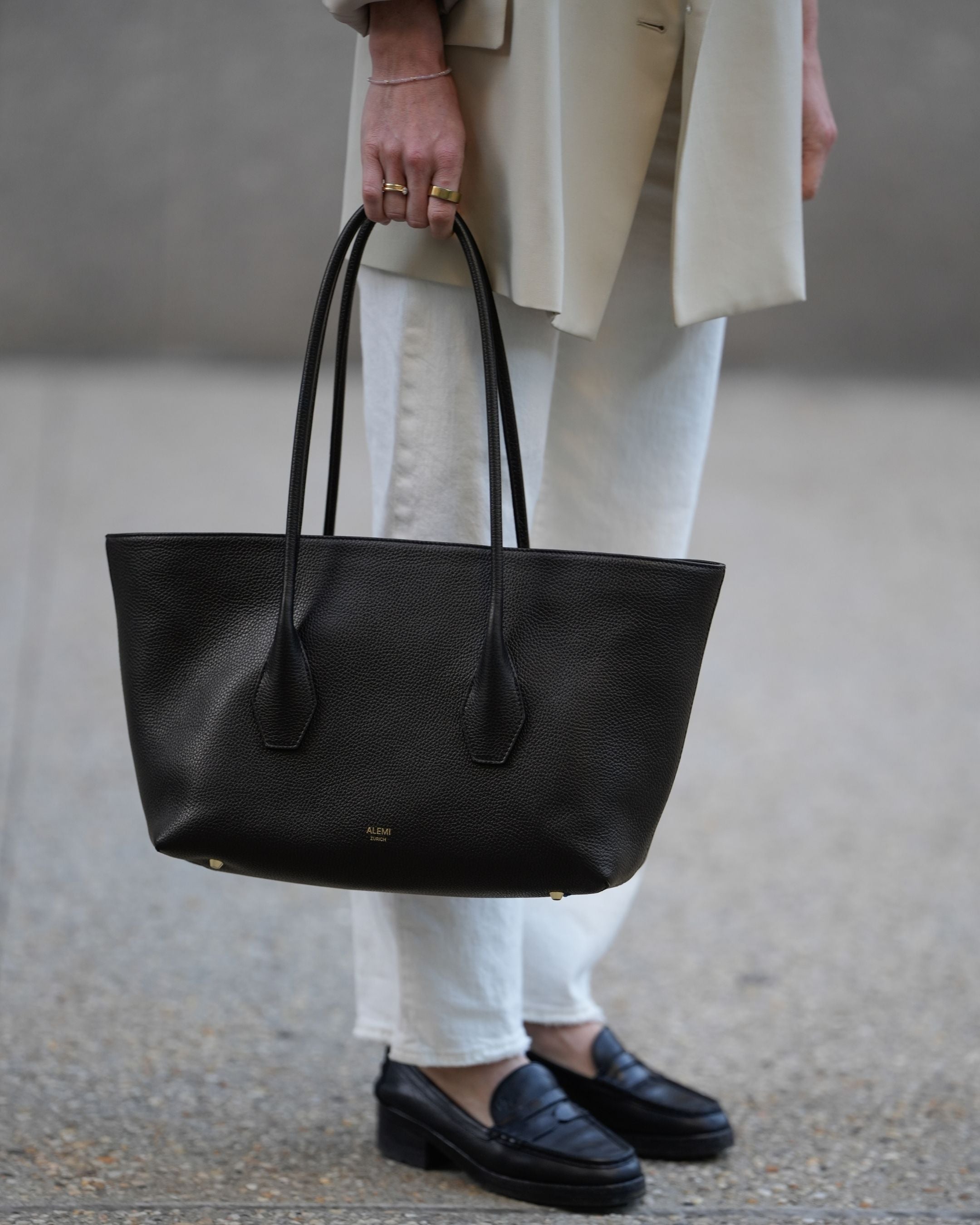 ALEMI Zurich | IDA | Laptop Bag | Black | Soft Grain Leather | Model carrying bag by handle
