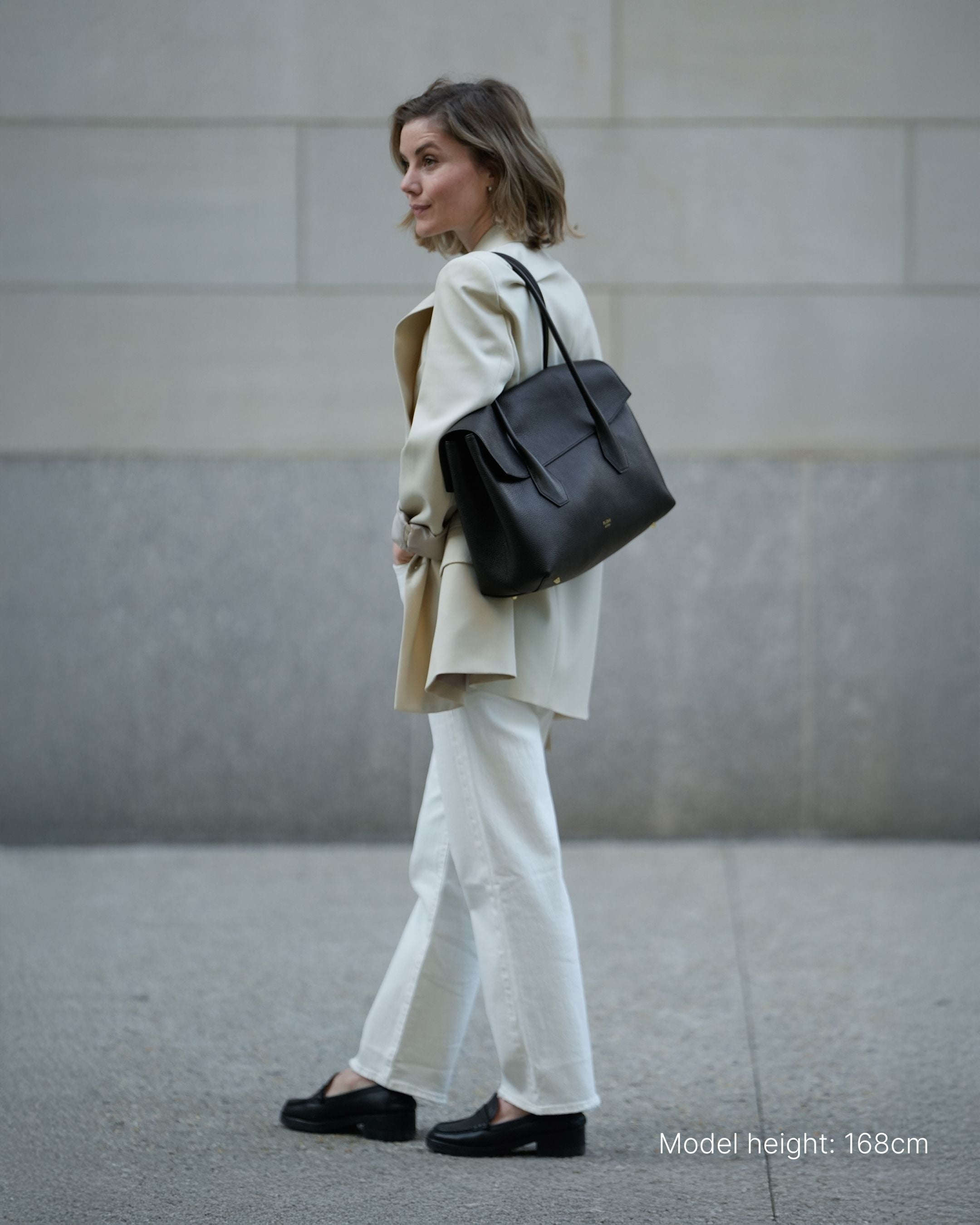 ALEMI Zurich | IDA | Laptop Bag | Black | Soft Grain Leather | Model carrying bag on shoulder