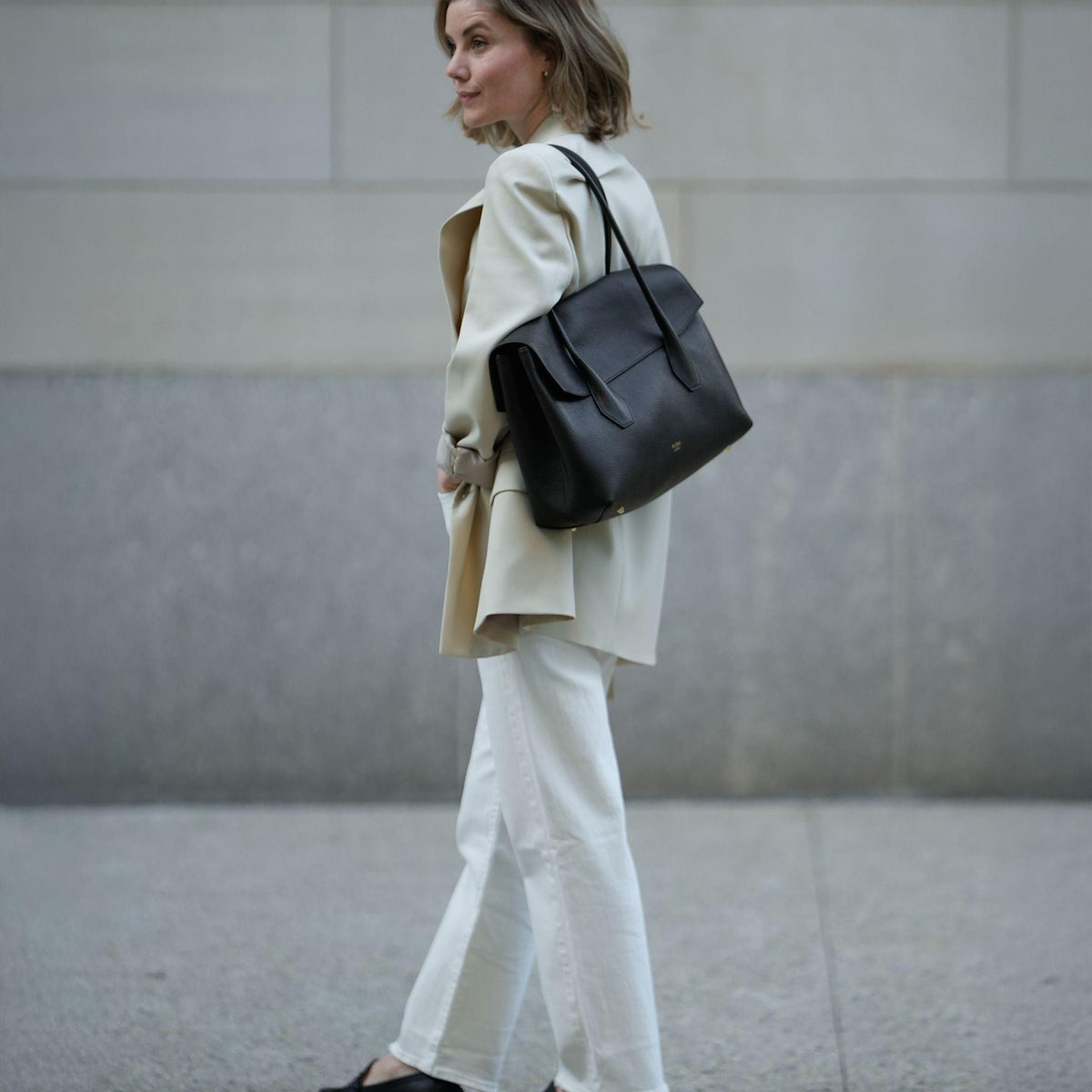 ALEMI Zurich | IDA | Laptop Bag | Black | Soft Grain Leather | Model carrying bag on shoulder