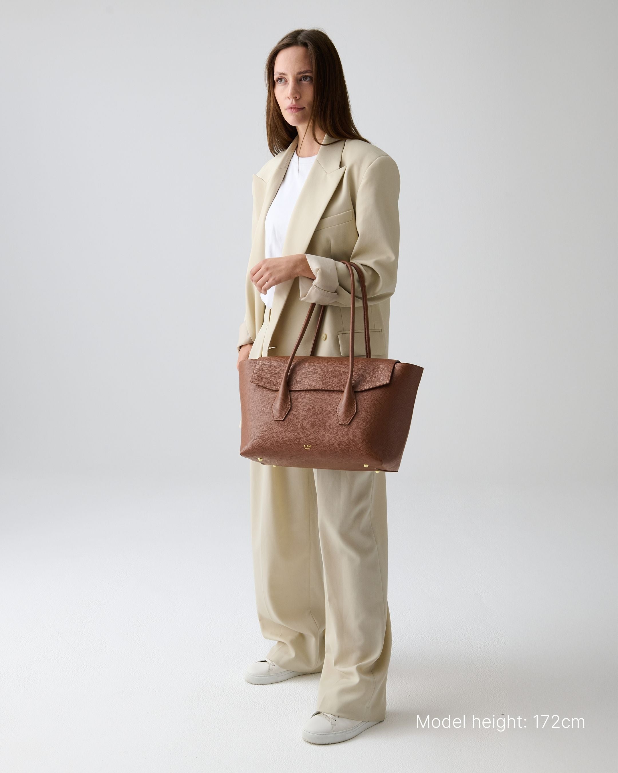 ALEMI Zurich | IDA | Laptop Bag | Cognac | Soft Grain Leather | Model carrying bag by handle