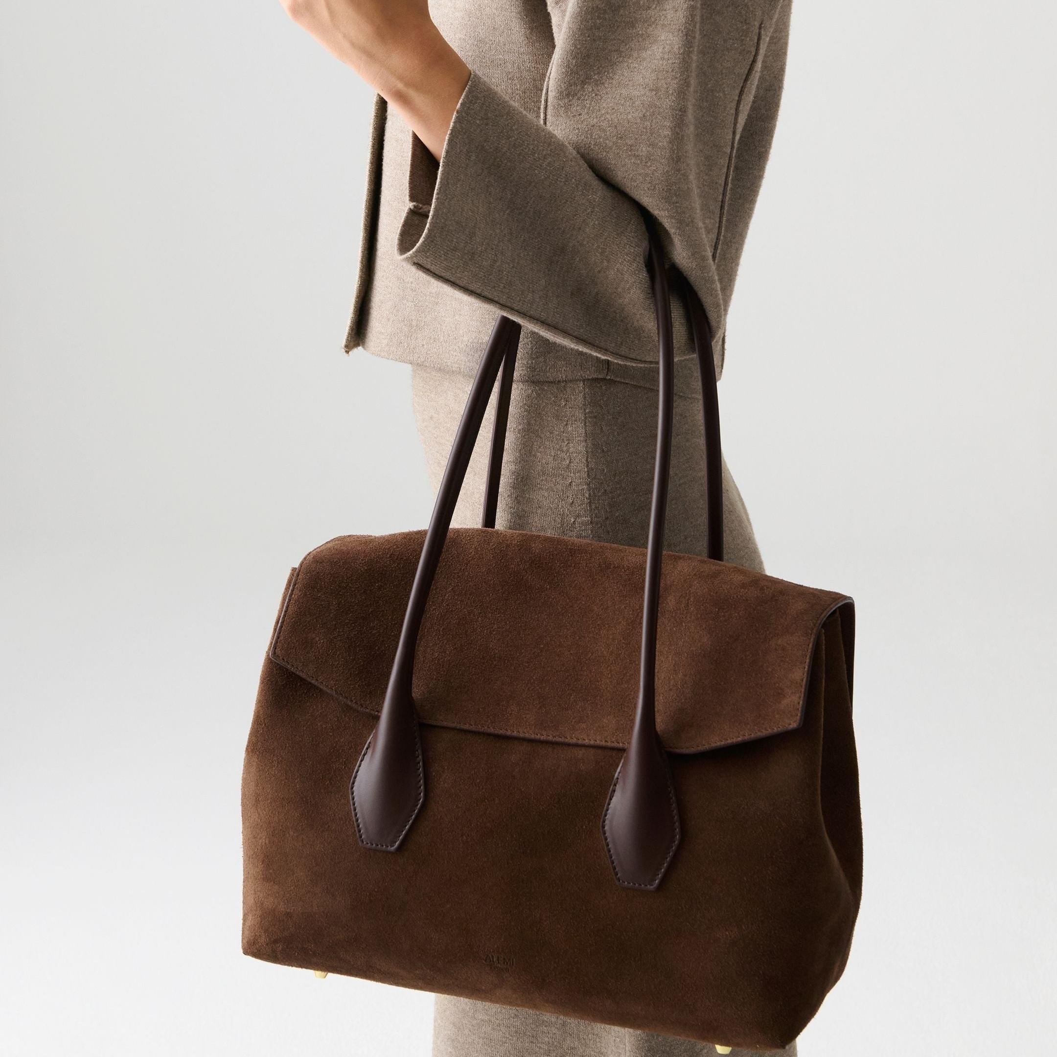 ALEMI Zurich | IDA | Laptop Bag | Dark Brown | Suede Leather | Model carrying bag by handle close up