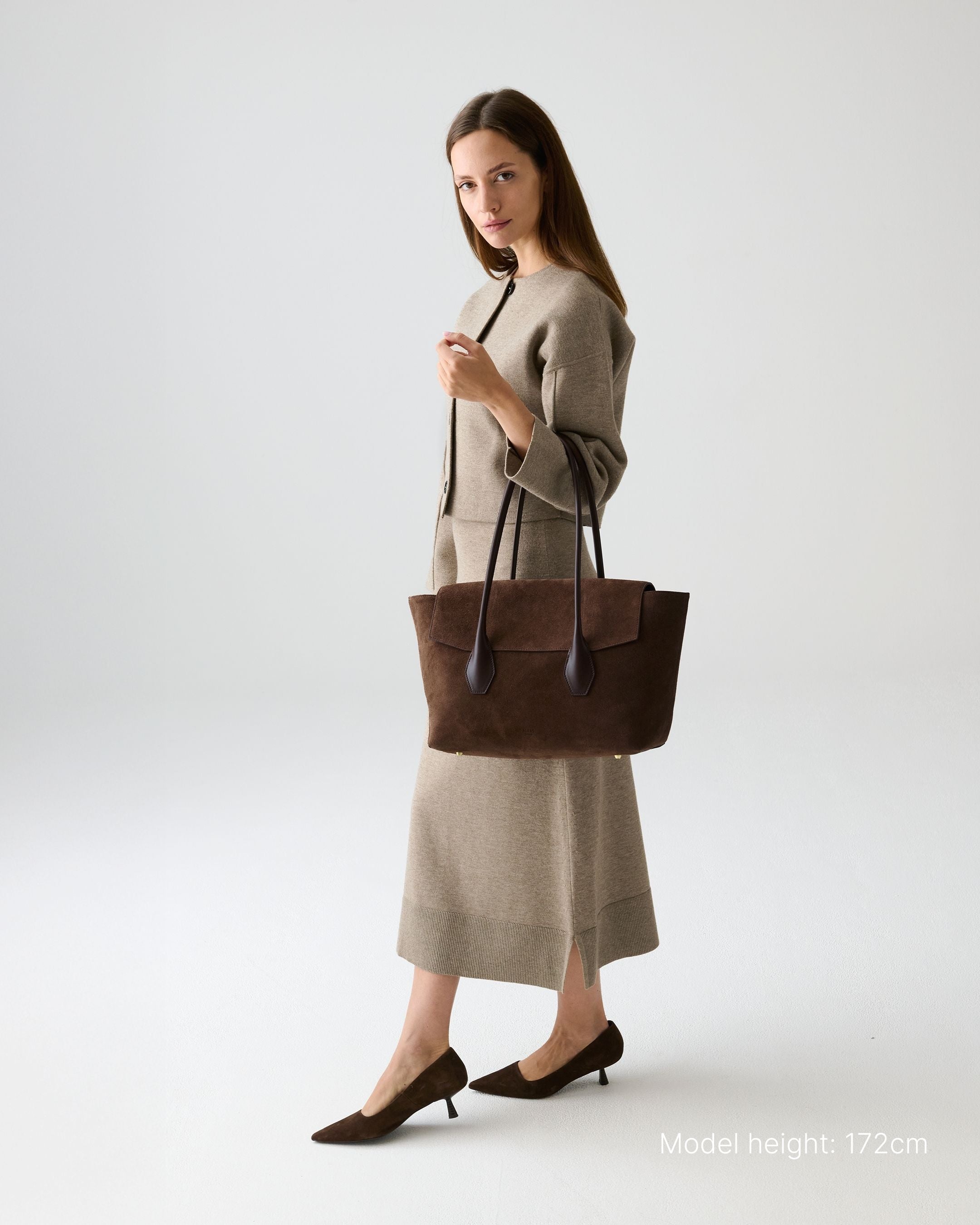 ALEMI Zurich | IDA | Laptop Bag | Dark Brown | Suede Leather | Model carrying bag by handle