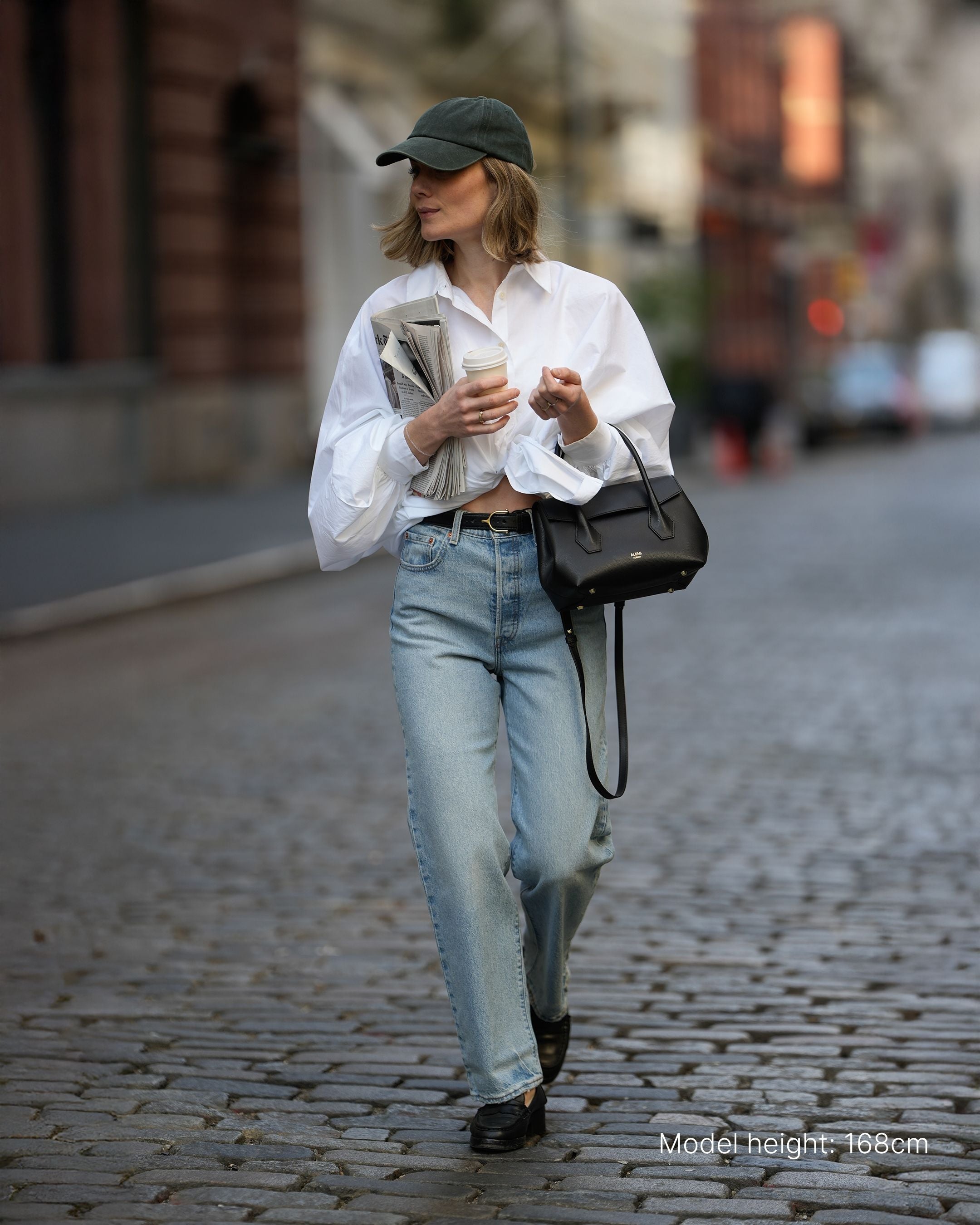 ALEMI Zurich | IDA SMALL | Small Bag | Black | Pebbled Leather | Model carrying bag by handle