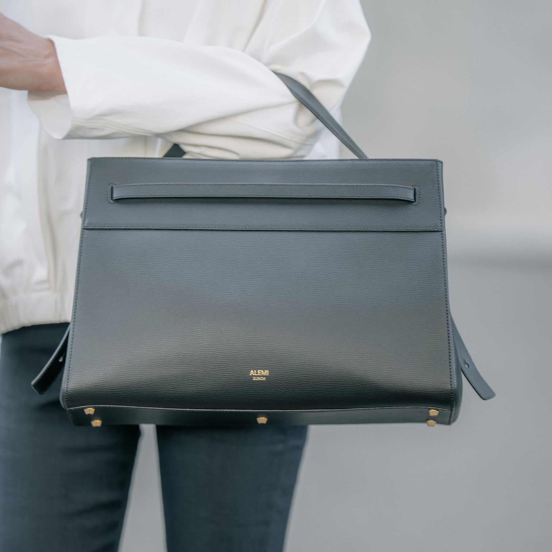 ALEMI Zurich | SEEFELD | Laptop Bag | Black | Pebbled Leather | Model carrying bag on shoulder close up