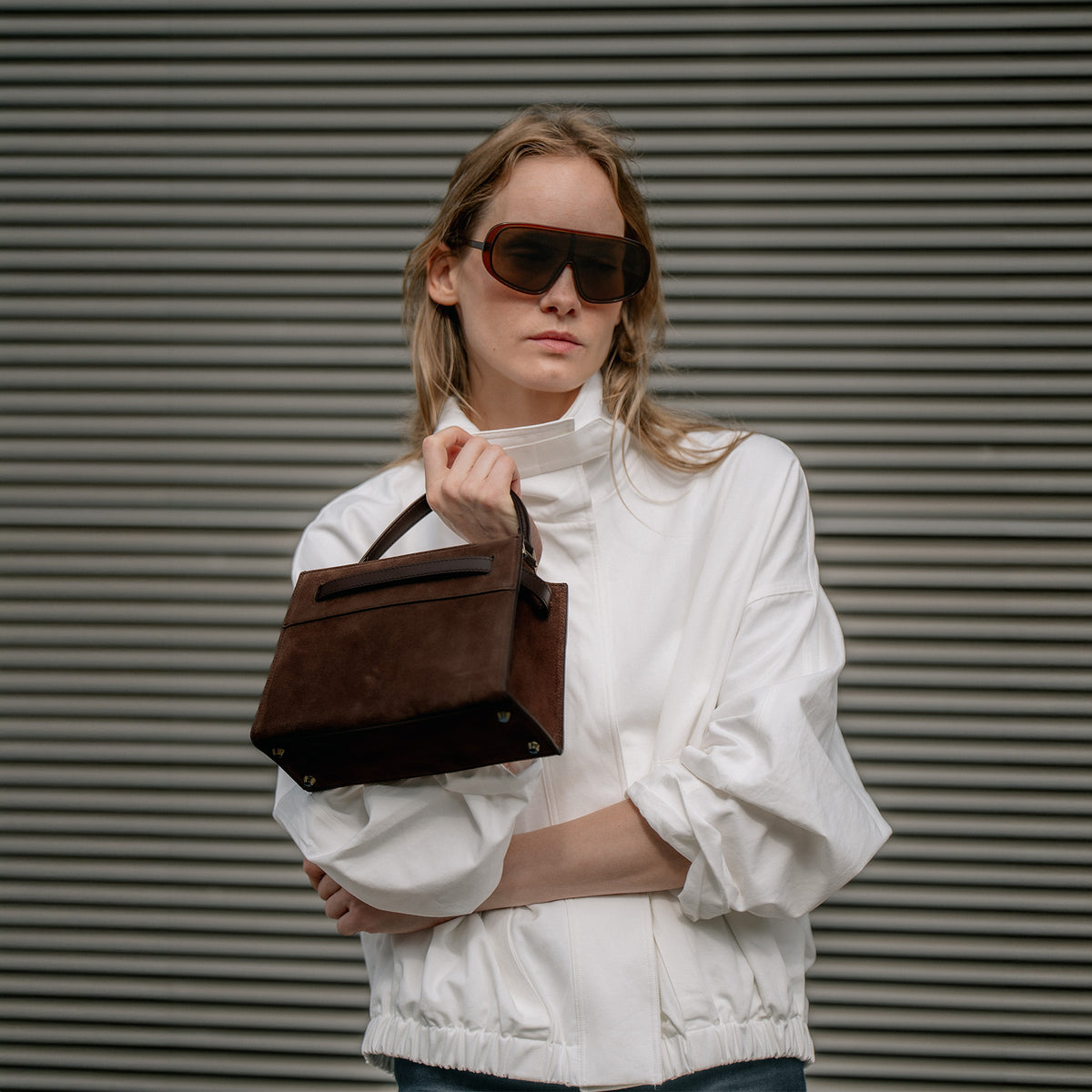 ALEMI Zurich | SEEFELD MINI | Small Bag | Dark Brown | Suede Leather | Model holding bag by handle