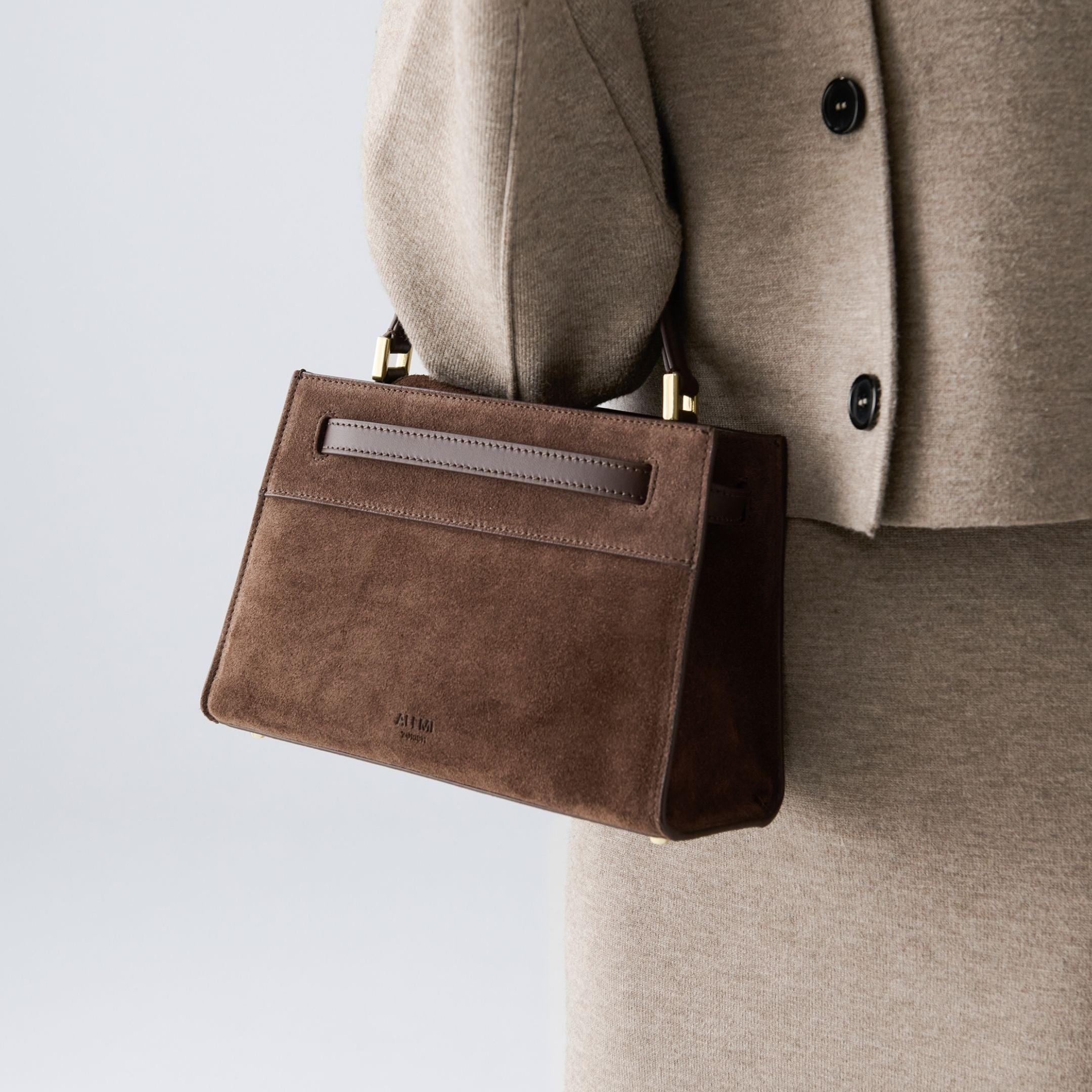 ALEMI Zurich | SEEFELD MINI | Small Bag | Dark Brown | Suede Leather | Model carrying bag by handle close up