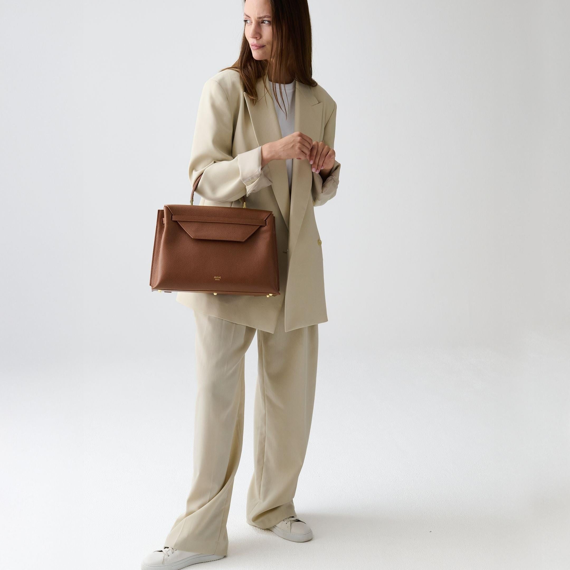 ALEMI Zurich | VIADUKT DAY | Laptop Bag | Cognac | Soft Grain Leather | Model carrying bag by handle