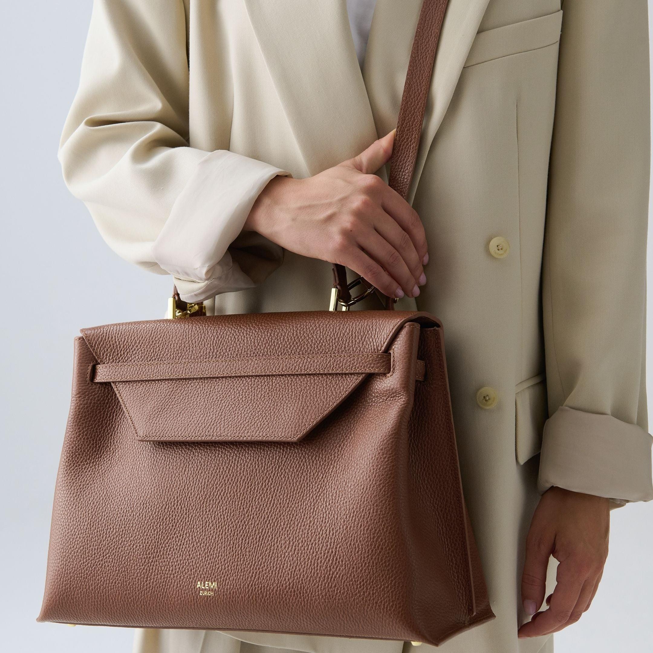 ALEMI Zurich | VIADUKT DAY | Laptop Bag | Cognac | Soft Grain Leather | Model carrying bag by strap