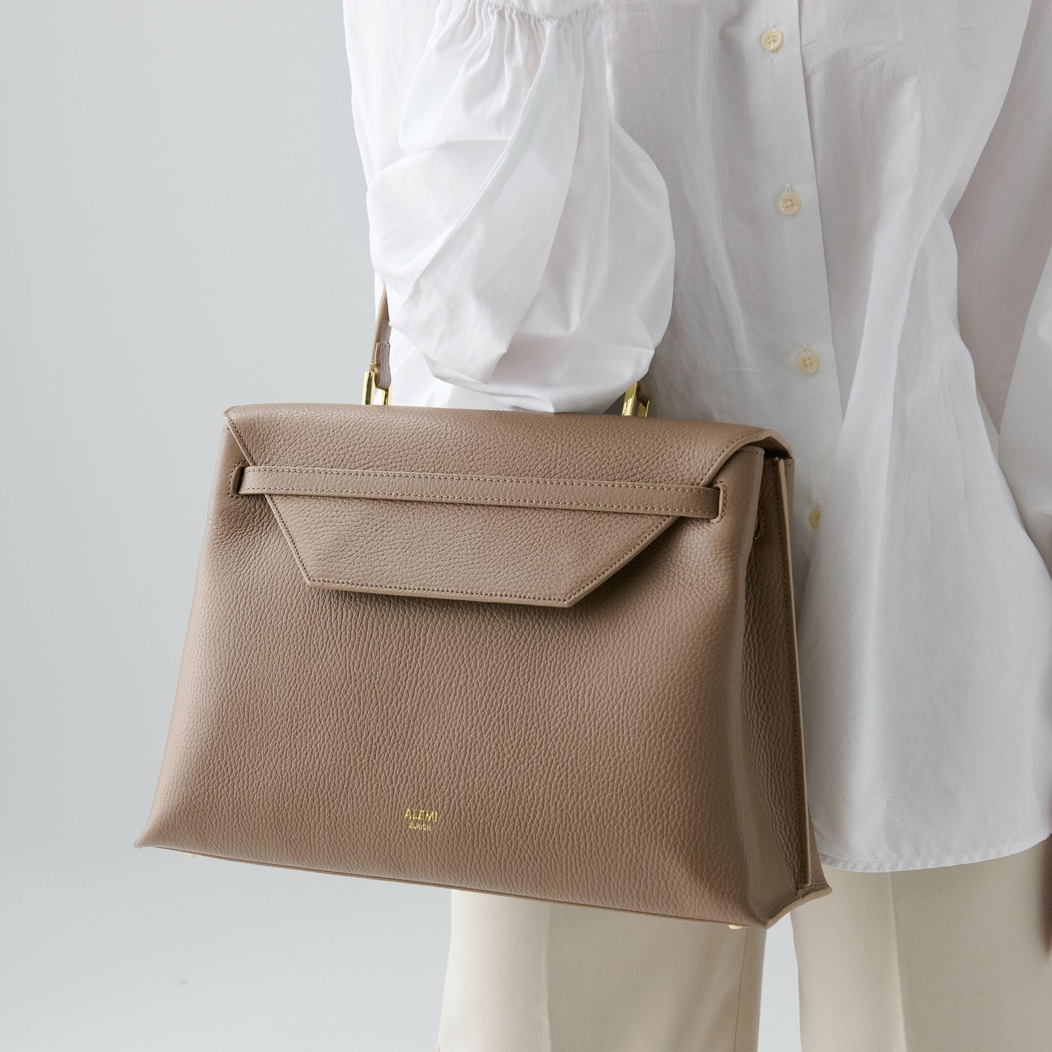 ALEMI Zurich | VIADUKT DAY | Laptop Bag | Greige | Soft Grain Leather | Model carrying bag by handle