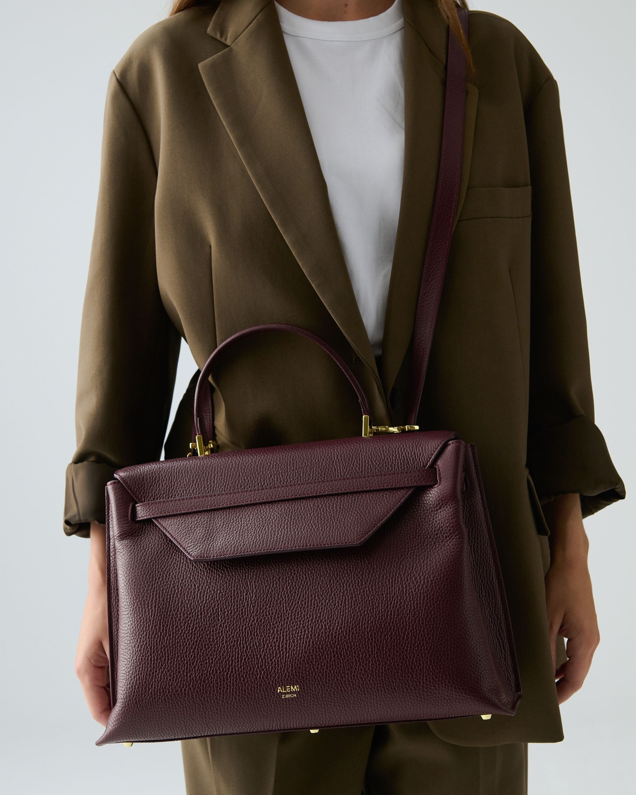 ALEMI Zurich | VIADUKT DAY | Laptop Bag | Maroon Red | Soft Grain Leather | Model carrying bag by strap