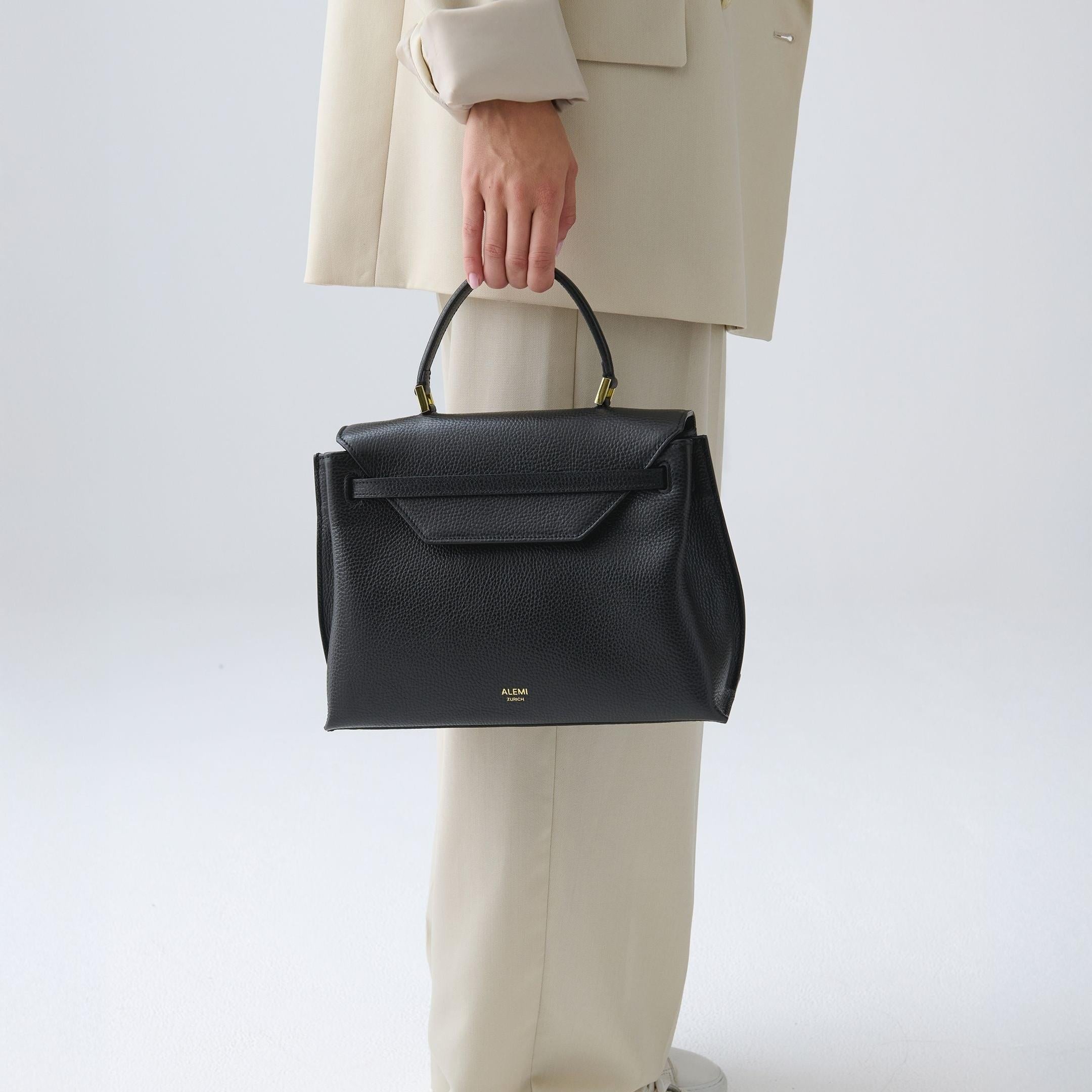 ALEMI Zurich | VIADUKT | Small Bag | Black | Soft Grain Leather | Model carrying bag by handle