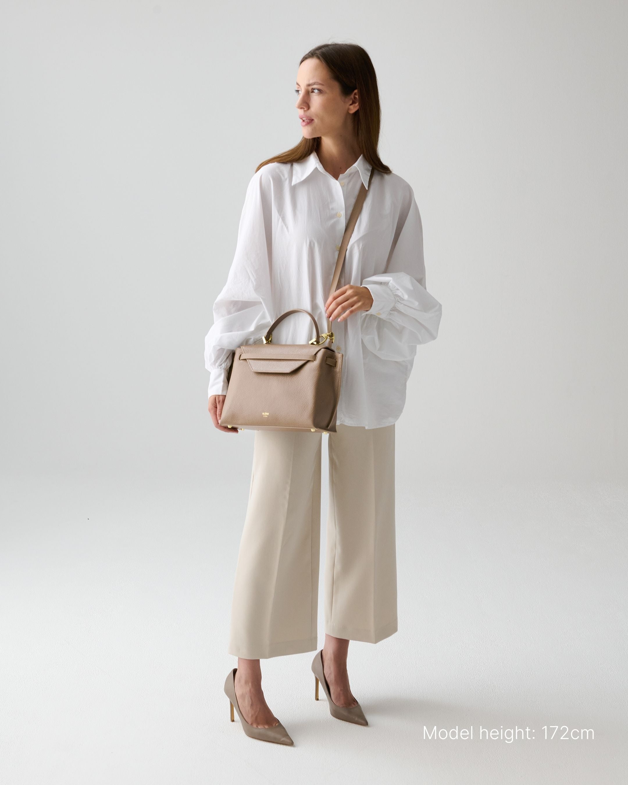 ALEMI Zurich | VIADUKT | Small Bag | Greige | Soft Grain Leather | Model carrying bag by strap
