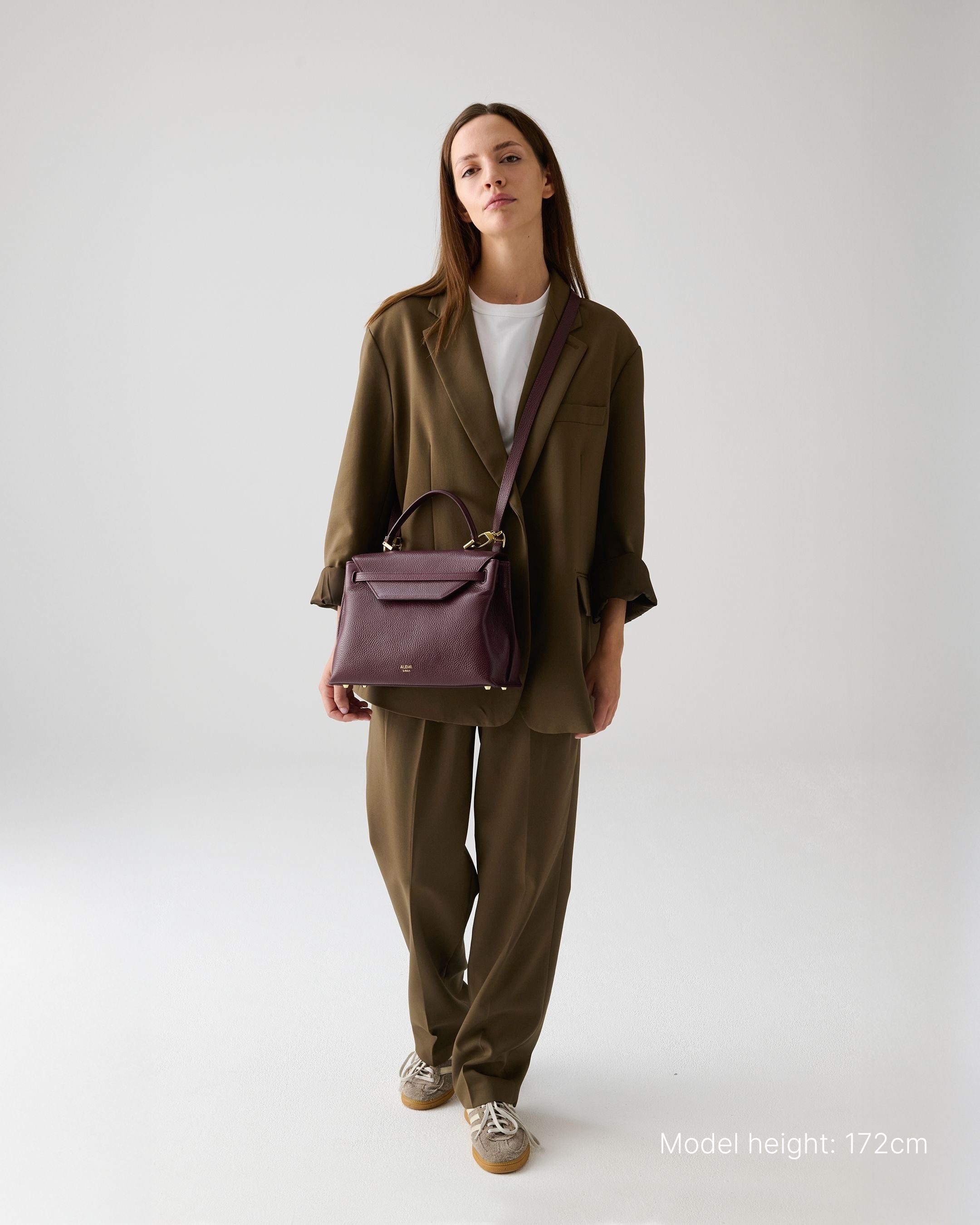 ALEMI Zurich | VIADUKT | Small Bag | Maroon Red | Soft Grain Leather | Model carrying bag by strap