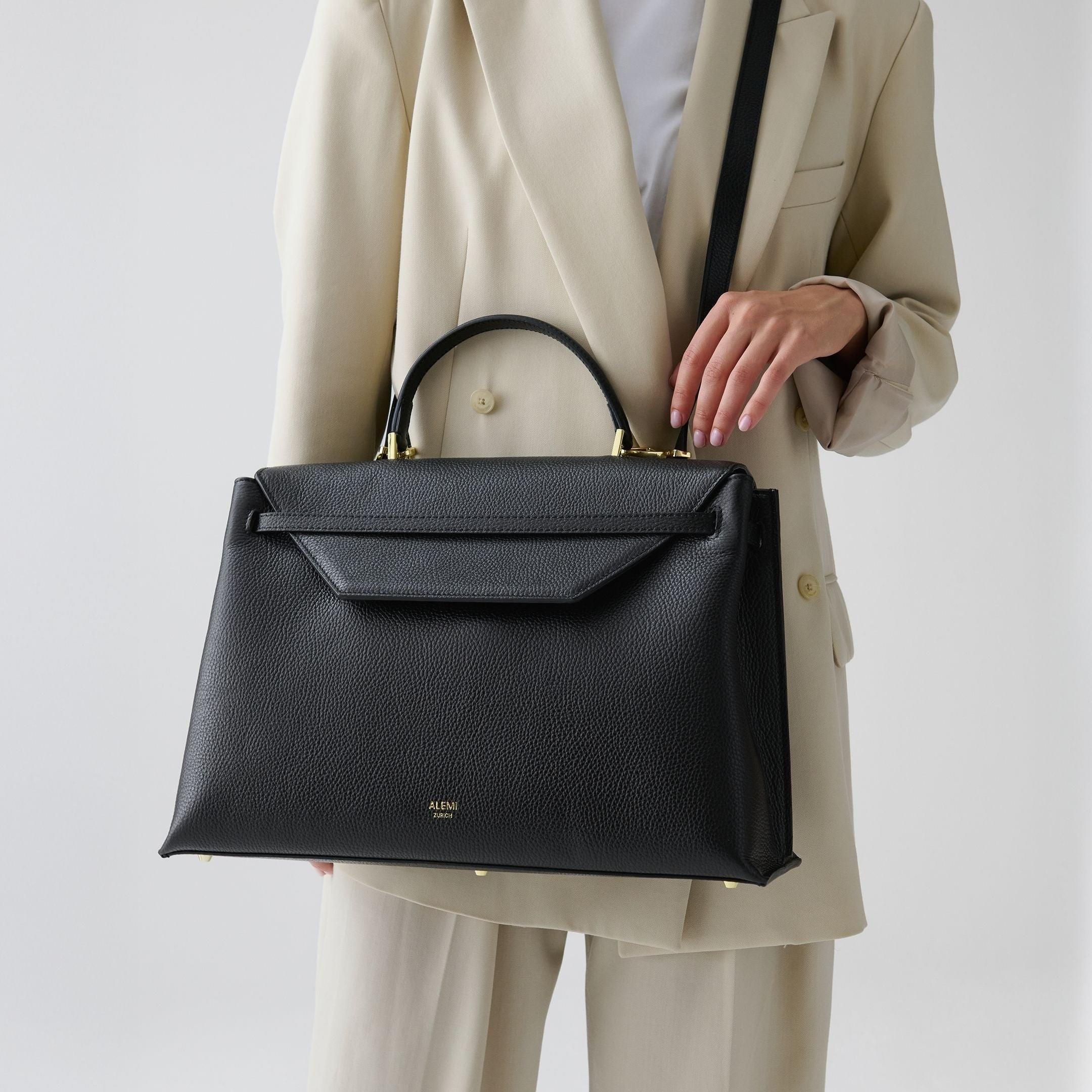 ALEMI Zurich | VIADUKT WORK | Laptop Bag | Black | Soft Grain Leather | Model carrying bag by strap