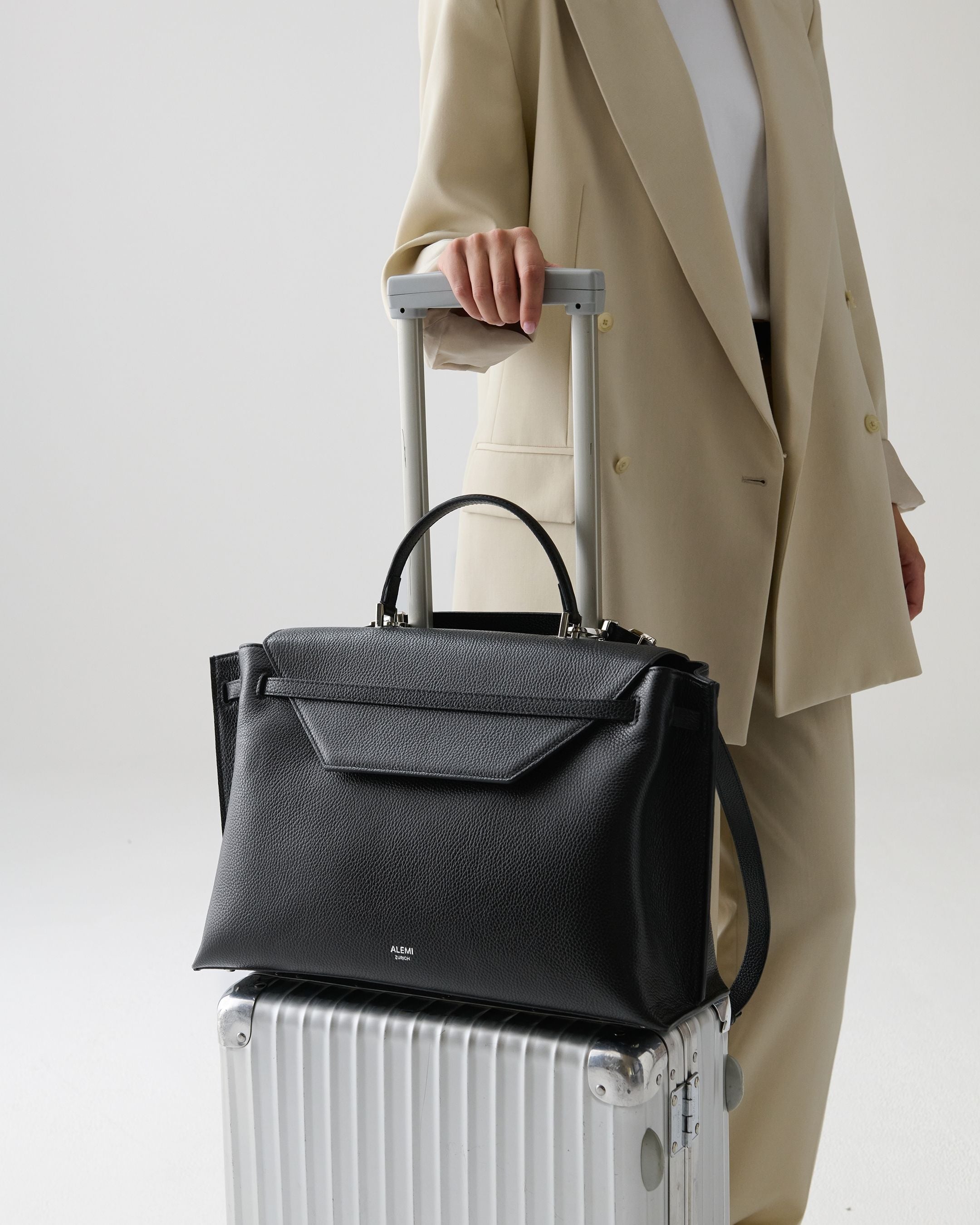 ALEMI Zurich | VIADUKT WORK | Laptop Bag | Black with Silver Hardware | Soft Grain Leather | Bag on luggage