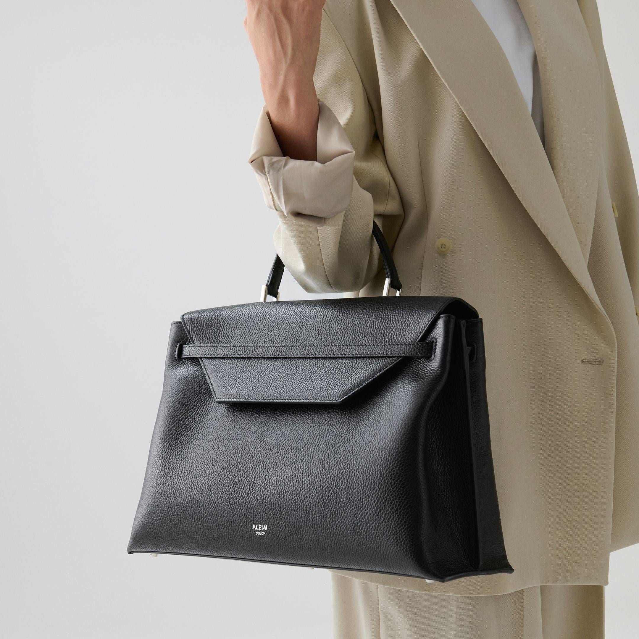 ALEMI Zurich | VIADUKT WORK | Laptop Bag | Black with Silver Hardware | Soft Grain Leather | Model carrying bag by handle-close-up