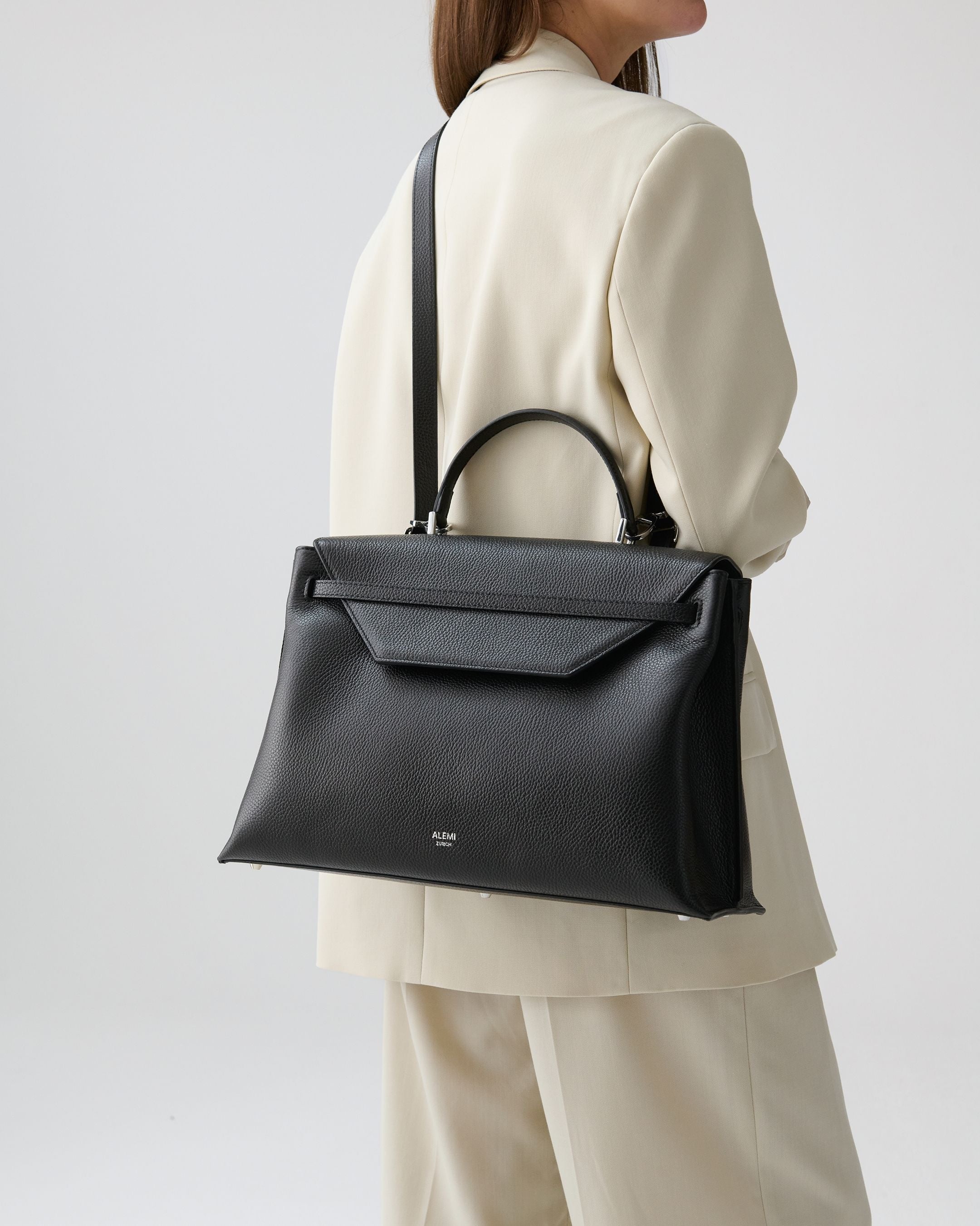 ALEMI Zurich | VIADUKT WORK | Laptop Bag | Black with Silver Hardware | Soft Grain Leather | Model carrying bag by strap