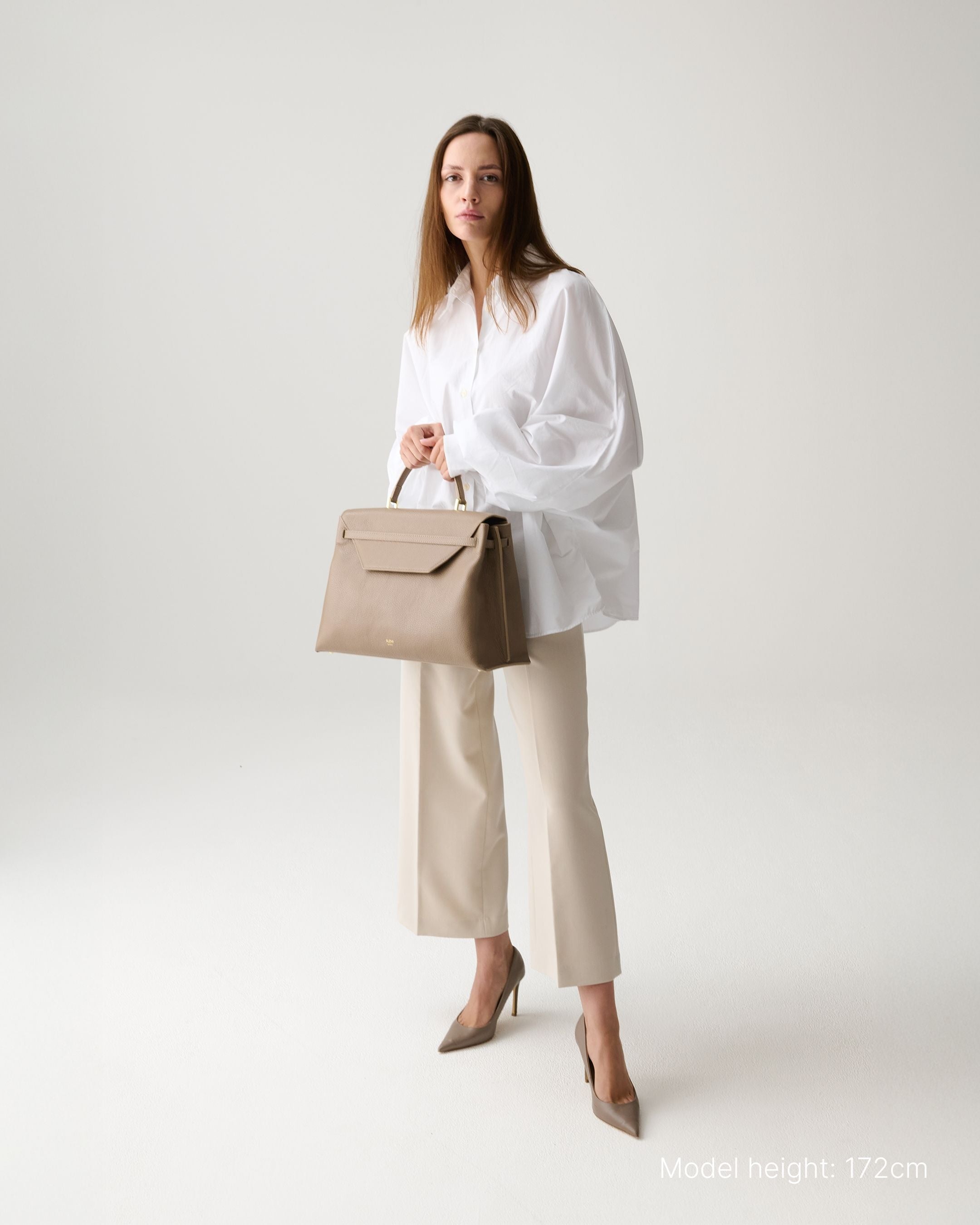 ALEMI Zurich | VIADUKT WORK | Laptop Bag | Greige | Soft Grain Leather | Model carrying bag by handle