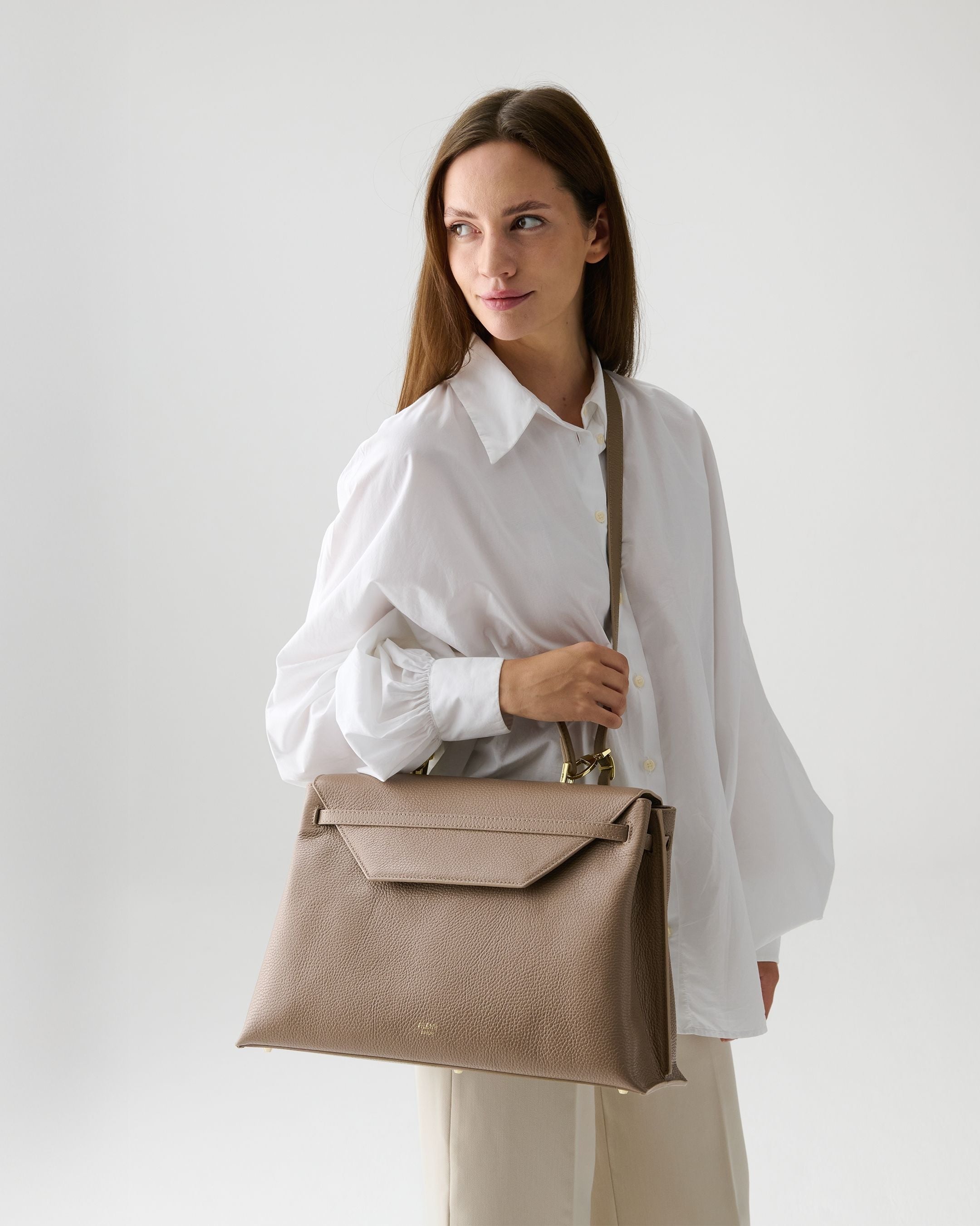 ALEMI Zurich | VIADUKT WORK | Laptop Bag | Greige | Soft Grain Leather | Model carrying bag by strap