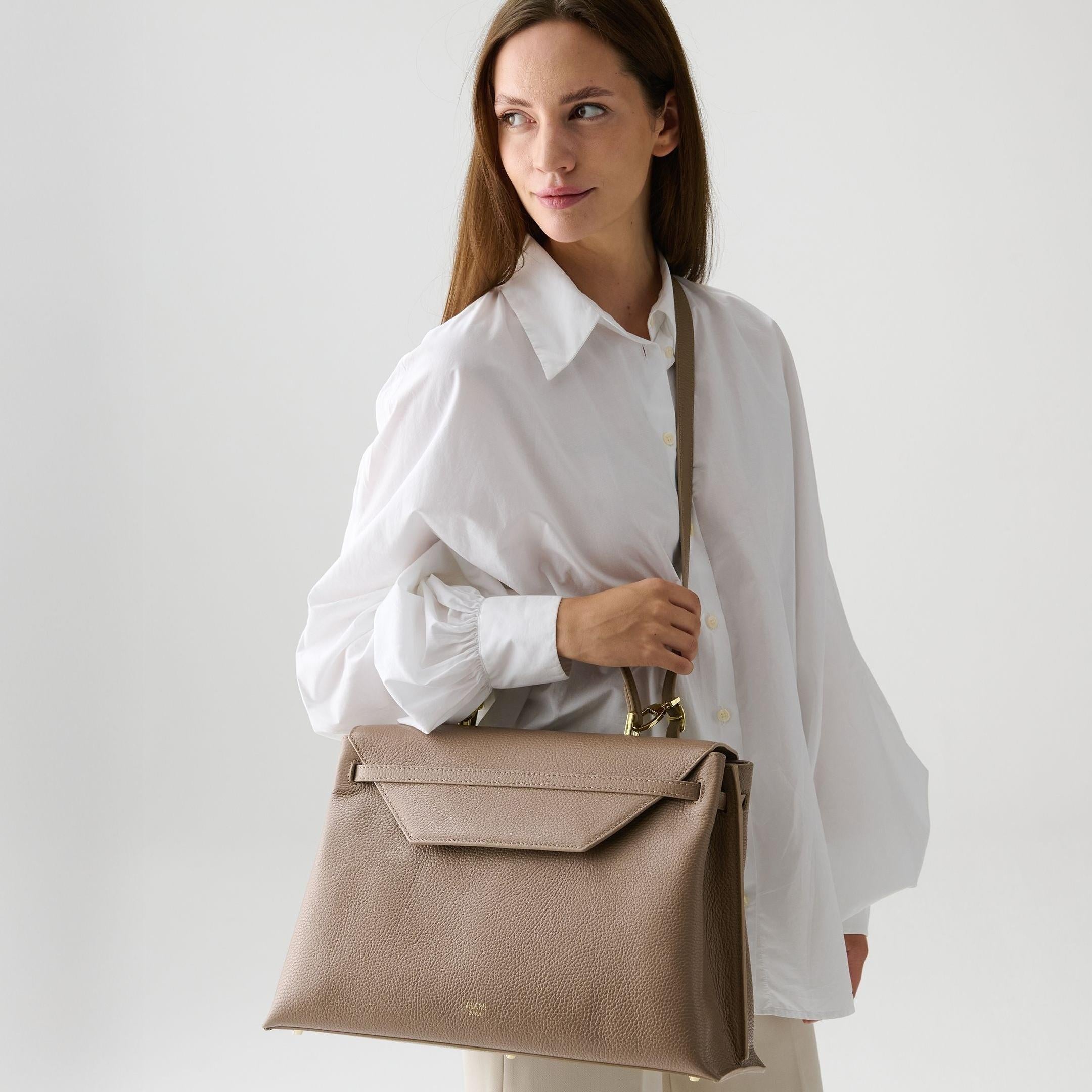 ALEMI Zurich | VIADUKT WORK | Laptop Bag | Greige | Soft Grain Leather | Model carrying bag by strap