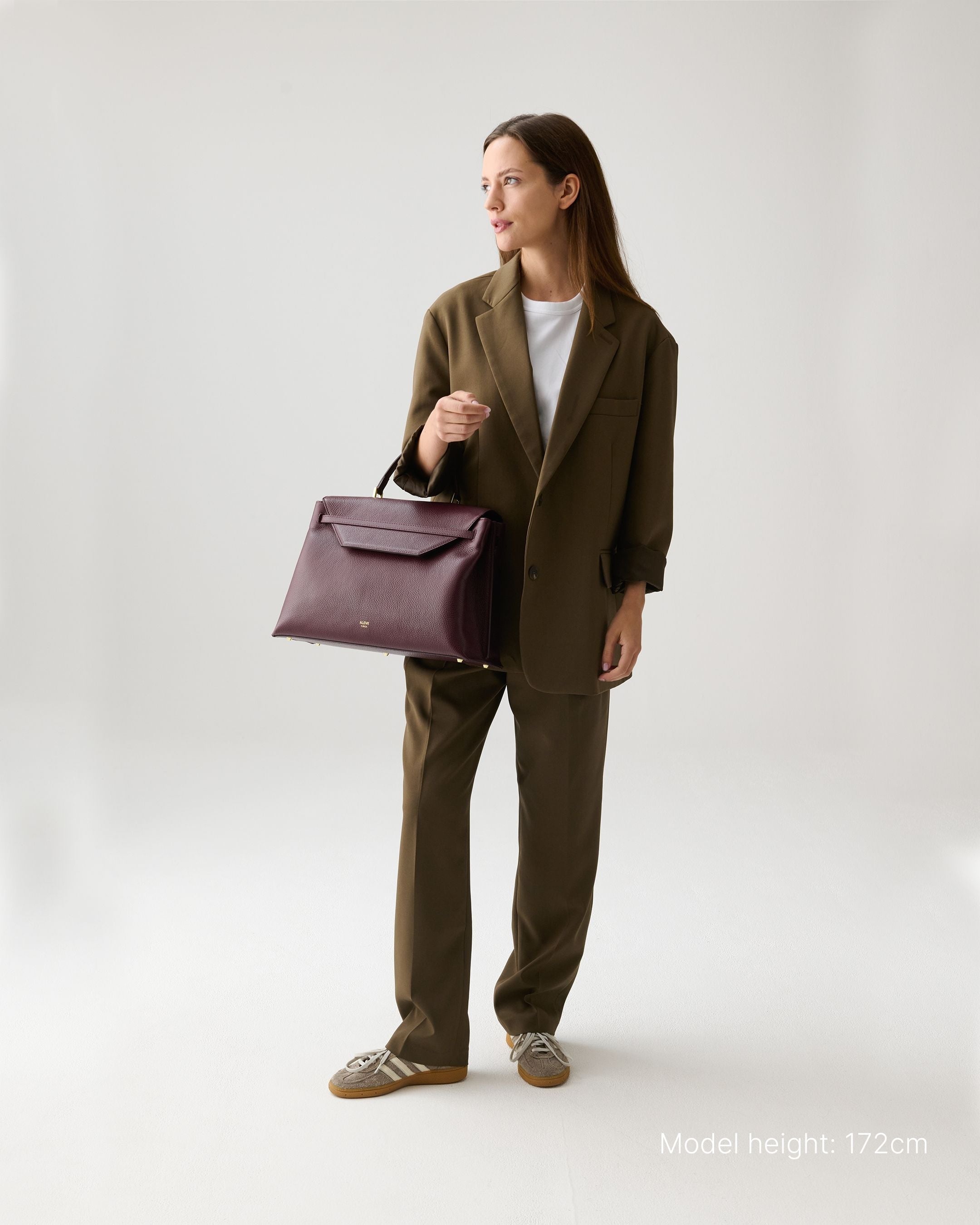 ALEMI Zurich | VIADUKT WORK | Laptop Bag | Maroon Red | Soft Grain Leather | Model carrying bag by handle