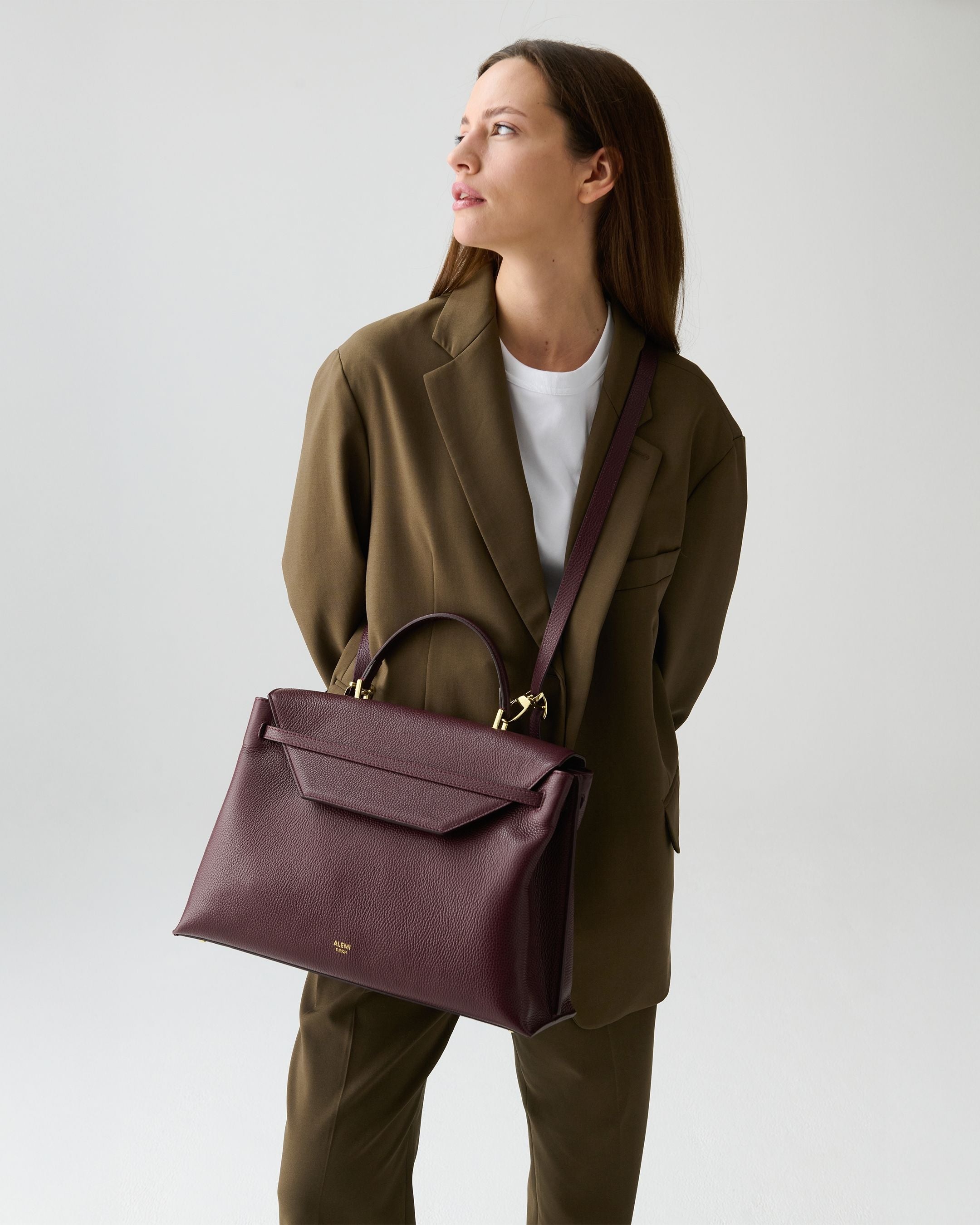 ALEMI Zurich | VIADUKT WORK | Laptop Bag | Maroon Red | Soft Grain Leather | Model carrying bag by strap