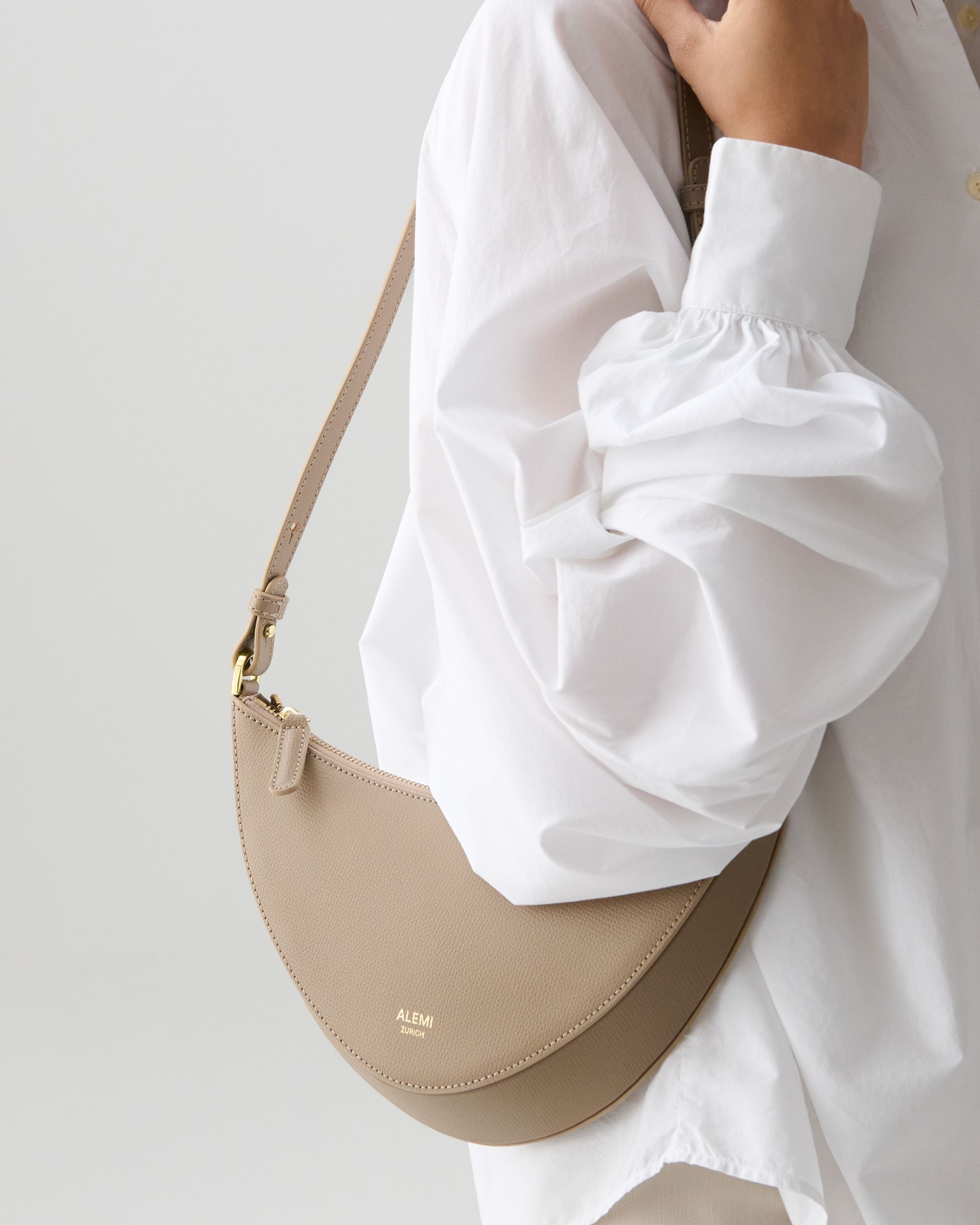 ALEMI Zurich | HELVETIA | Small Bag | Greige | Pebbled Leather | Model carrying bag on shoulder