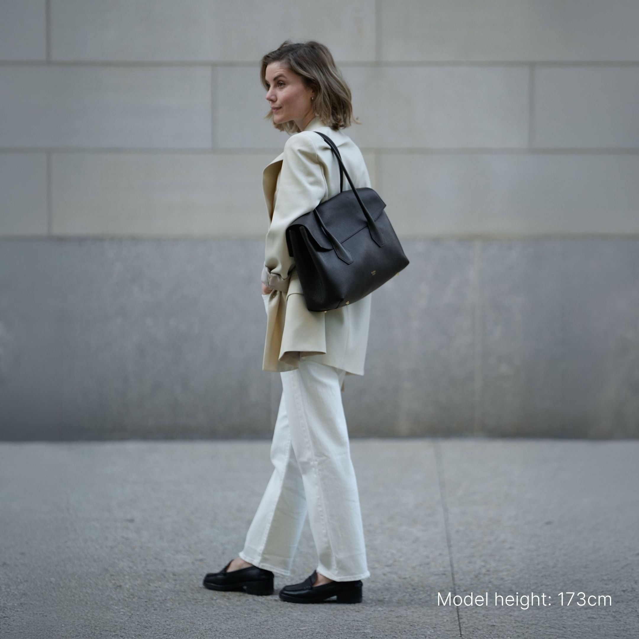 ALEMI Zurich | IDA | Laptop Bag | Black | Soft Grain Leather | Model carrying bag on shoulder