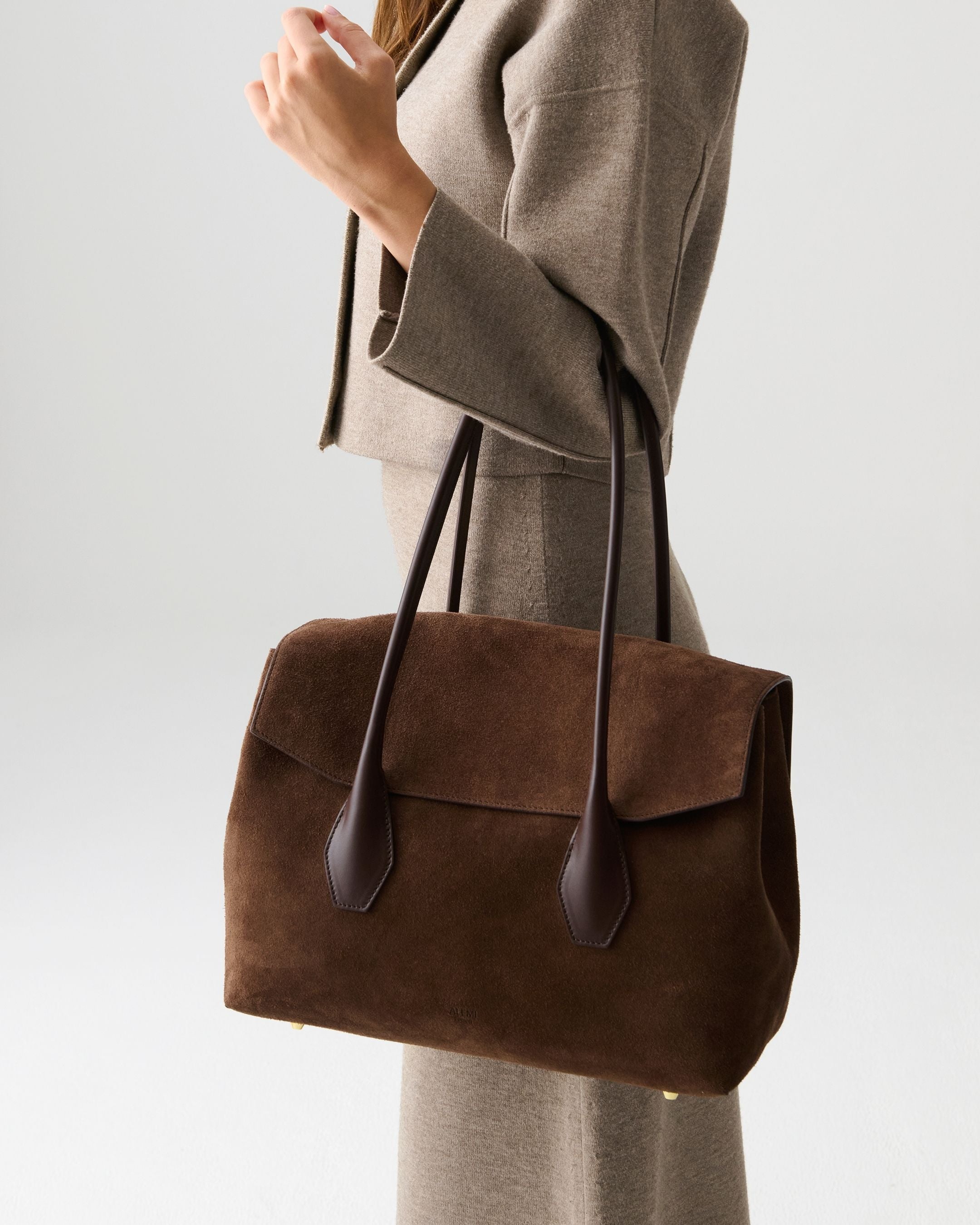 ALEMI Zurich | IDA | Laptop Bag | Dark Brown | Suede Leather | Model carrying bag by handle close up