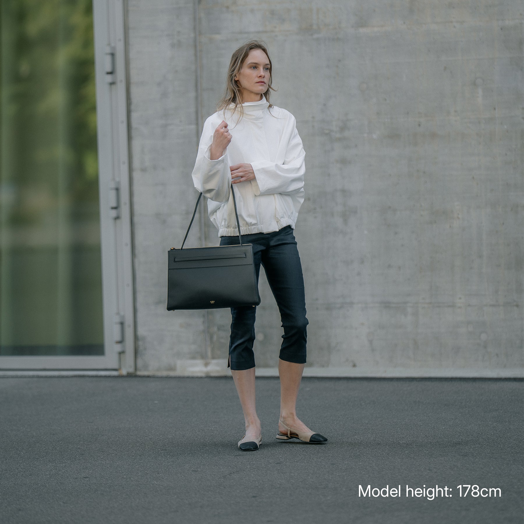 ALEMI Zurich | SEEFELD | Laptop Bag | Black | Pebbled Leather | Model carrying bag on shoulder full look