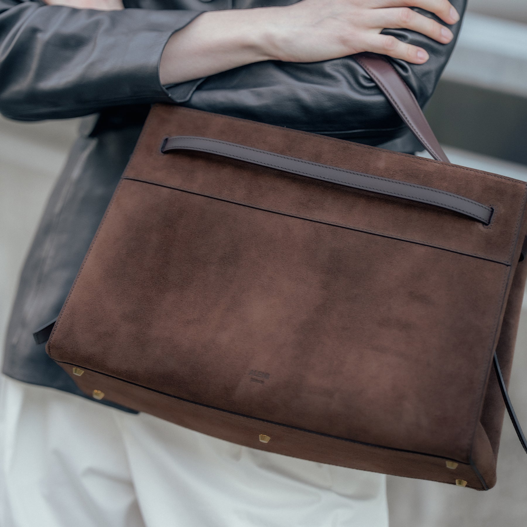 ALEMI Zurich | SEEFELD | Laptop Bag | Dark Brown | Suede Leather | Model carrying bag on shoulder close up