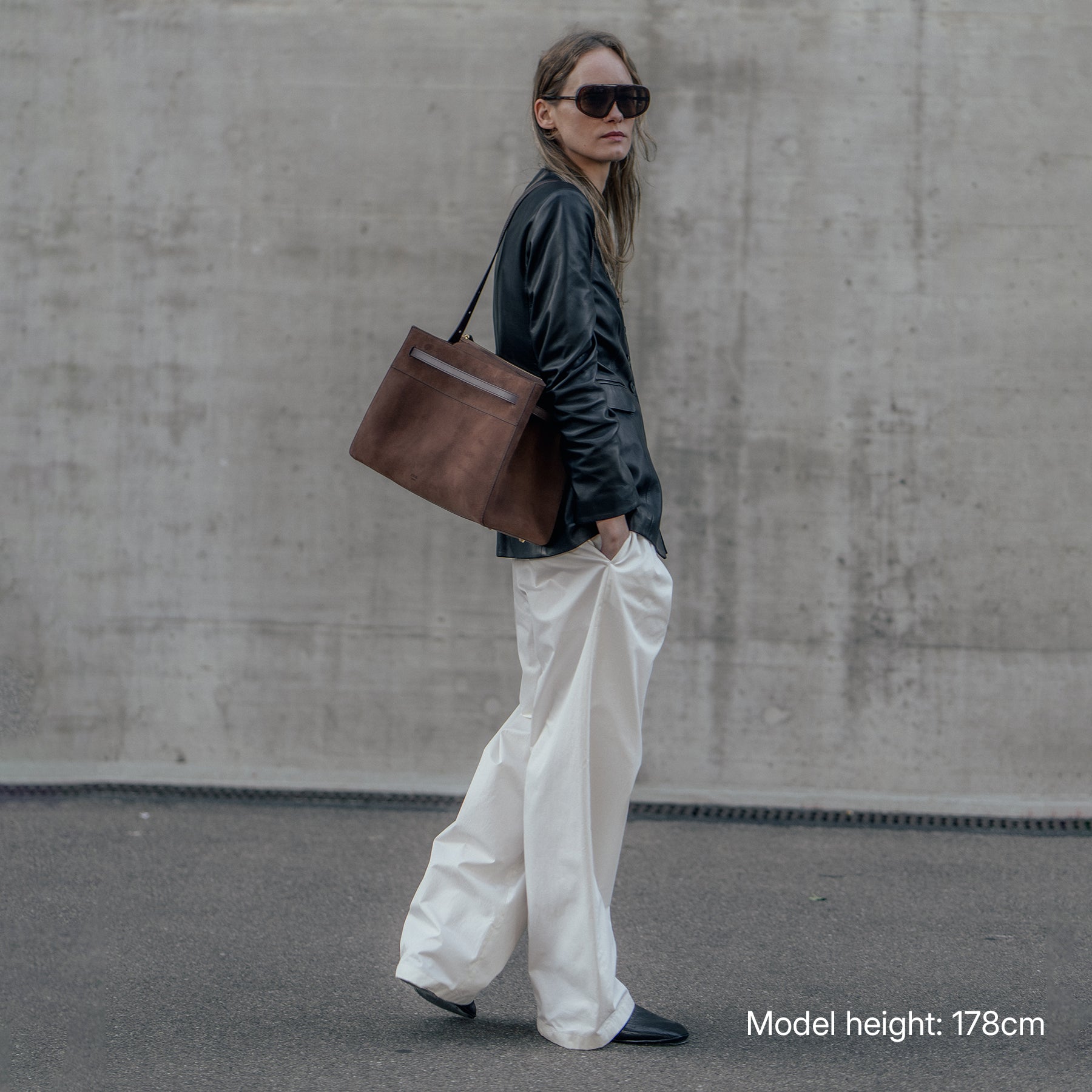 ALEMI Zurich | SEEFELD | Laptop Bag | Dark Brown | Suede Leather | Model carrying bag on shoulder full look