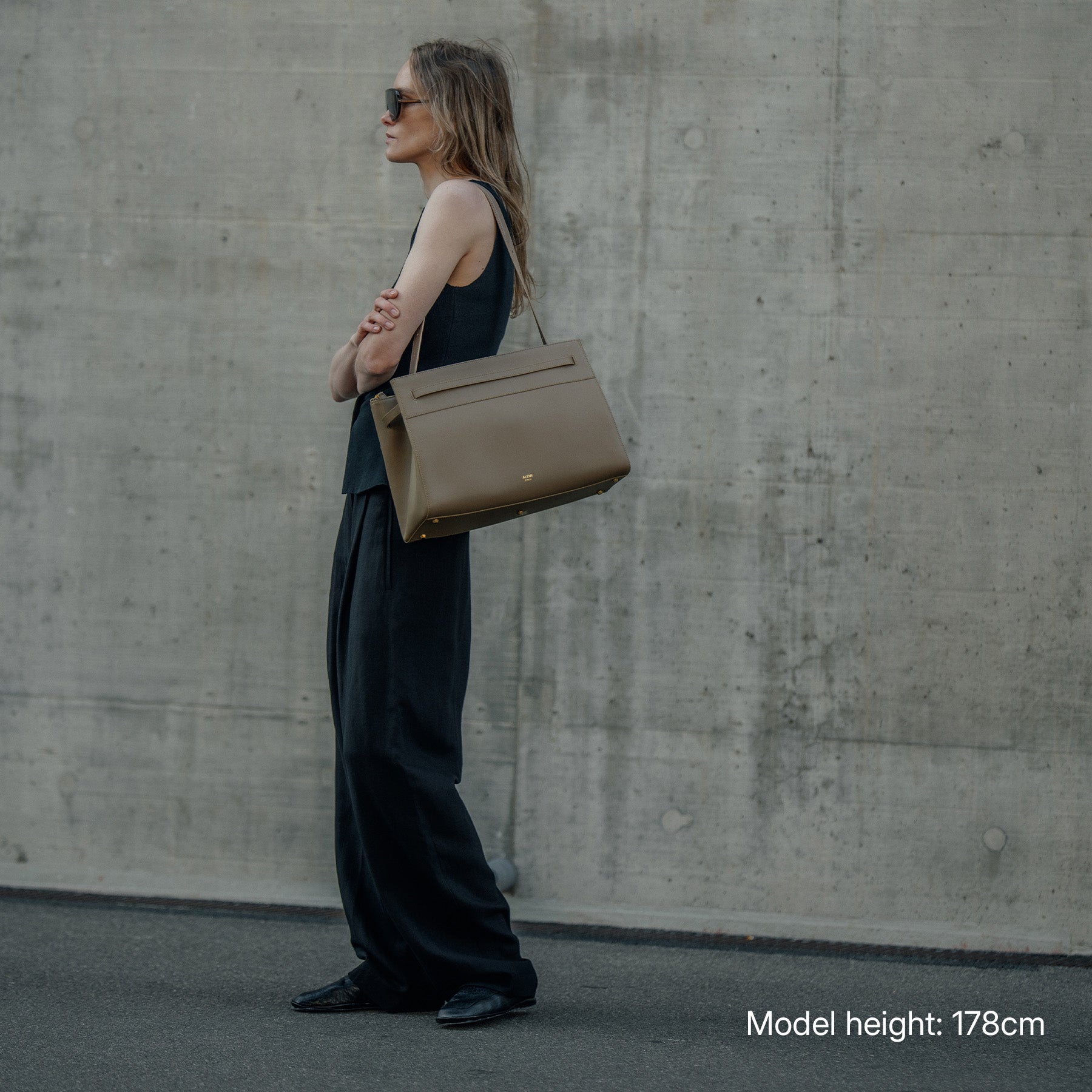 ALEMI Zurich | SEEFELD | Laptop Bag | Greige | Pebbled Leather | Model carrying bag on shoulder full look
