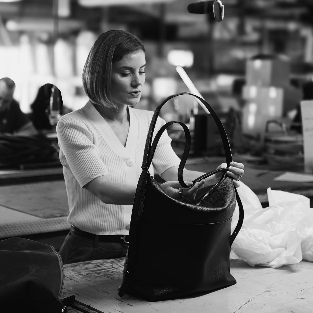 Craftswoman assembling an ALEMI bag by hand in the Italian atelier
