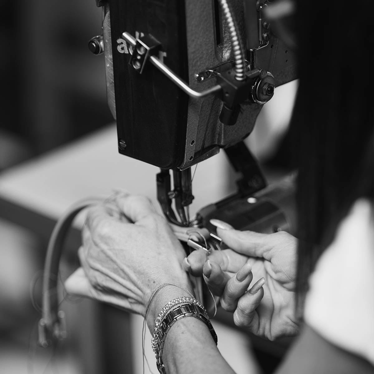 Craftswoman stitching a leather handle on the sewing machine