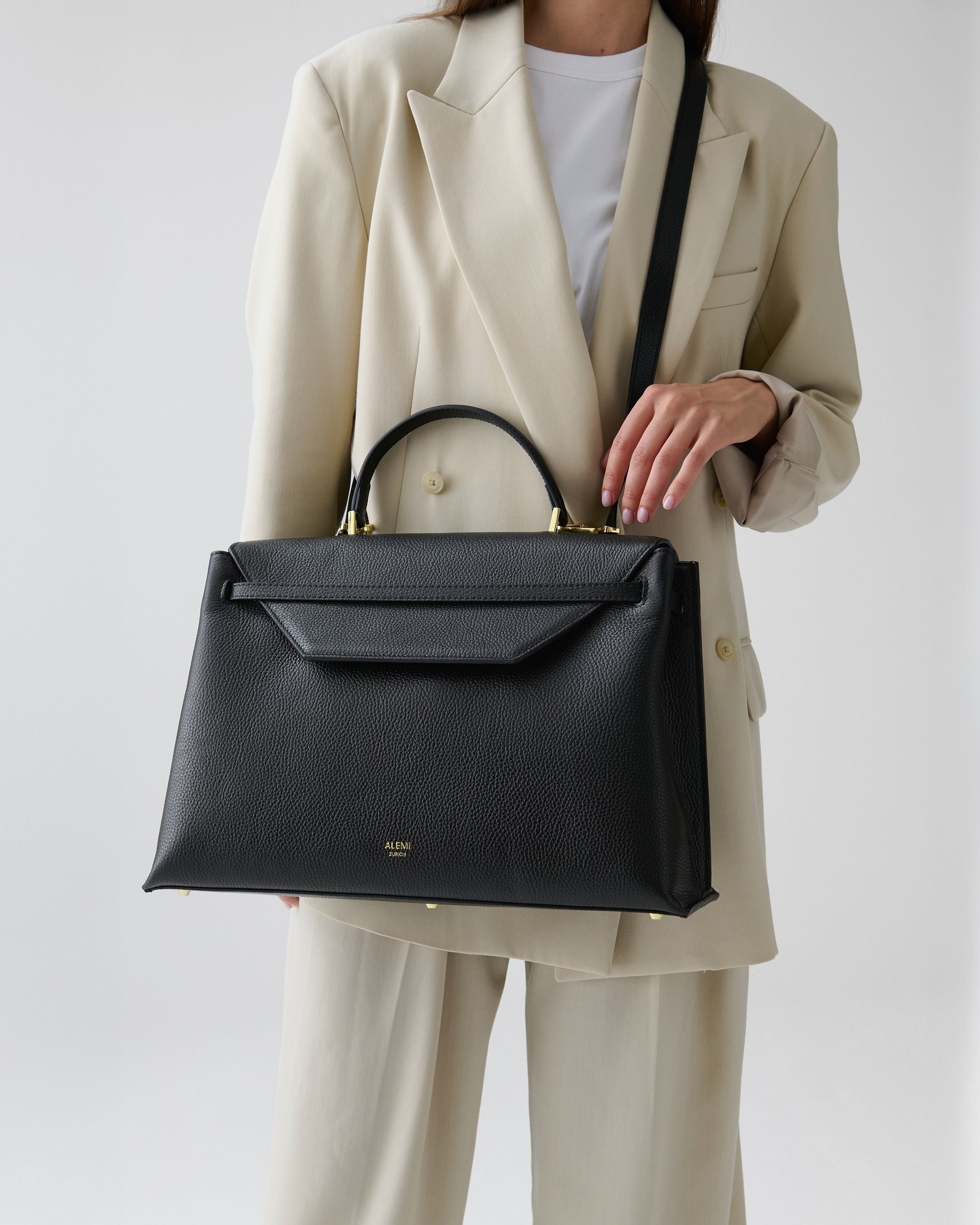 ALEMI Zurich | VIADUKT WORK | Laptop Bag | Black | Soft Grain Leather | Model carrying bag by strap