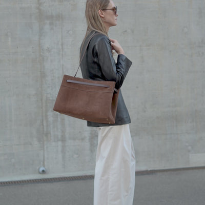 ALEMI Zurich | SEEFELD | Laptop Bag | Dark Brown | Suede Leather | Video model carrying bag on shoulder